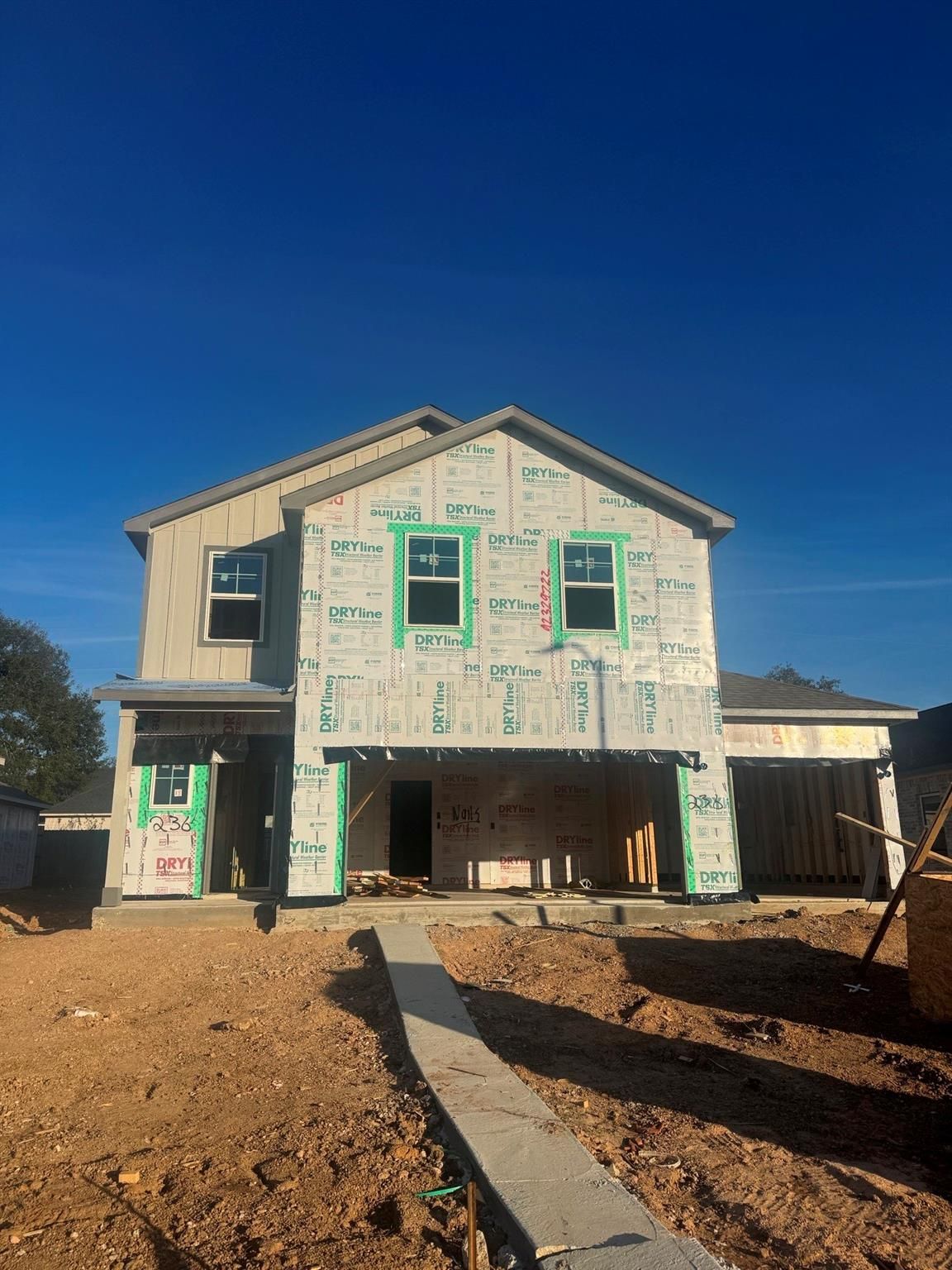 Two-story 5-bedroom home under construction with sheathed exterior, windows, and 3-car garage in Windmill Estates, Magnolia, Texas