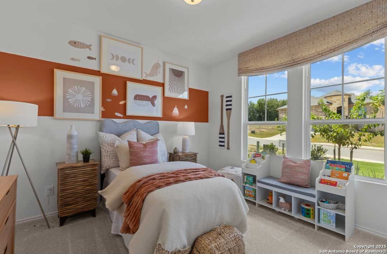 Cozy child's bedroom with nautical wall art, orange accent wall, and arched window in The Daphne J home, Elmendorf, Texas