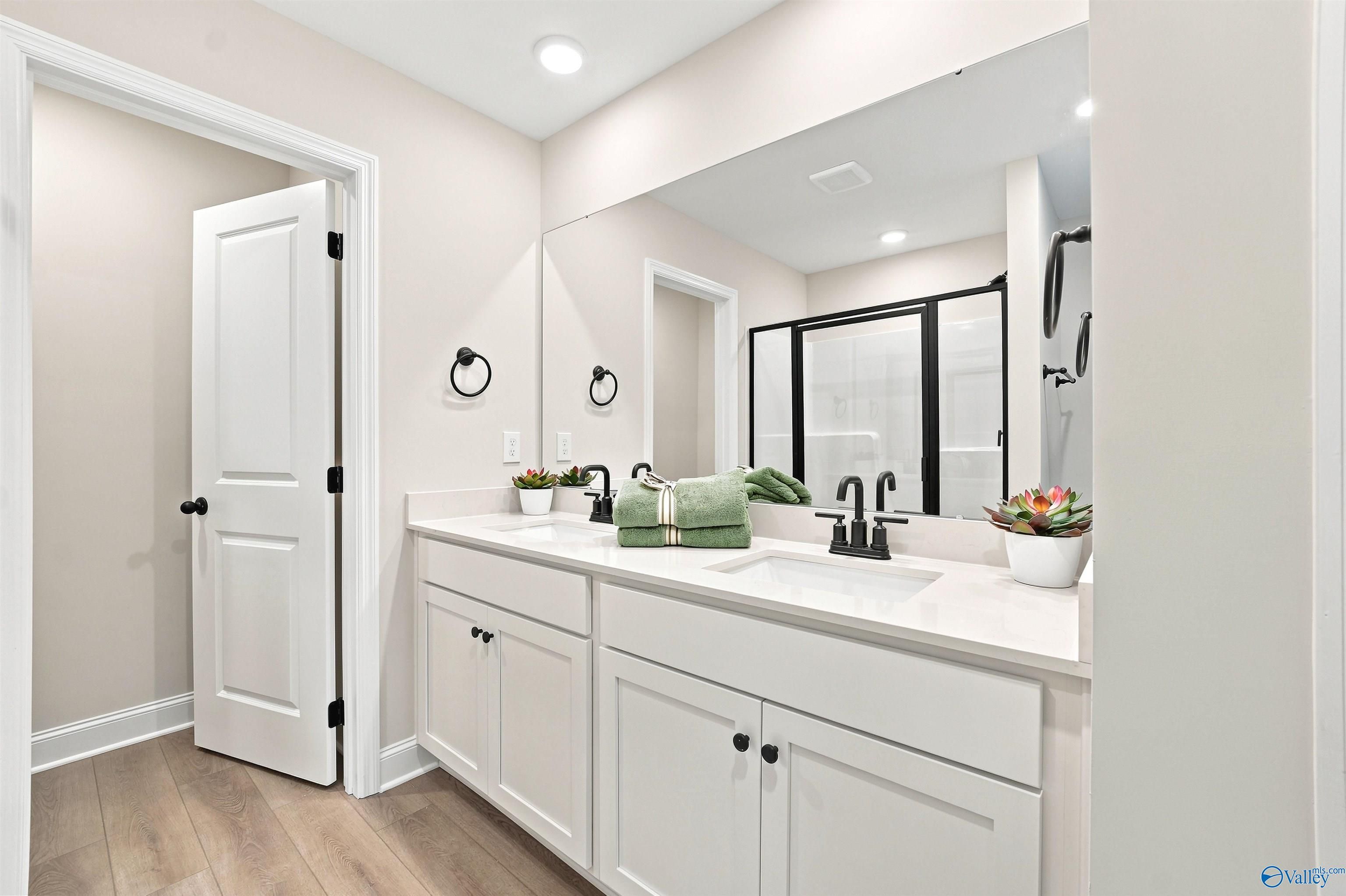 Modern dual-sink vanity with white cabinets in The Burton B floor plan at Heritage Lakes, New Market, Alabama.