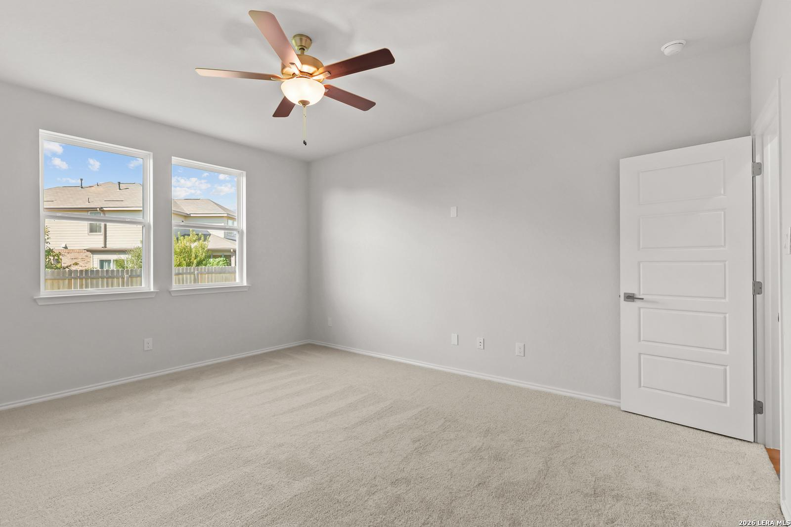 Bright bedroom with ceiling fan, carpet flooring, and dual windows in Davidson Homes The Daphne I, Bricewood, San Antonio, Texas