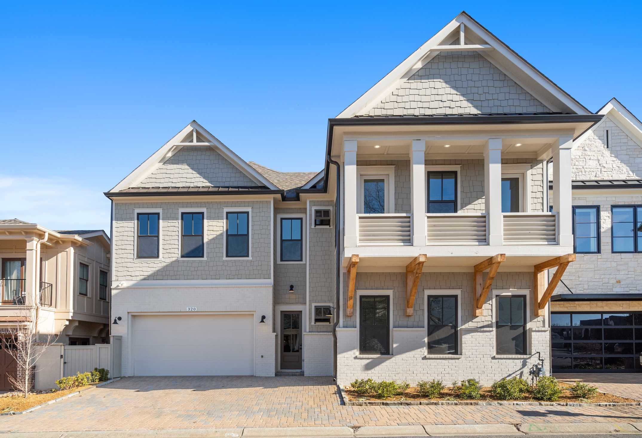 Modern two-story Seaside home elevation with shake siding, upper balcony, and three-car garage in Woodstock, GA