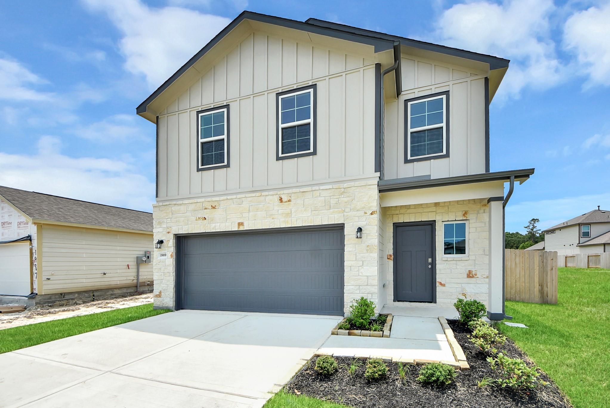 Two-story Blanco E floor plan by Davidson Homes with stone facade and two-car garage in The Villages at WestPointe, Texas.