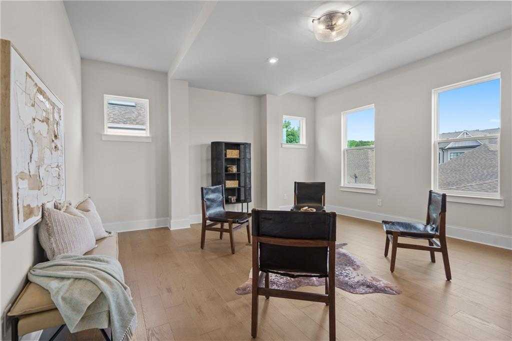 Cozy study with black leather chairs, hardwood floors, bench seating and large windows in Davidson Homes The Seaside B, Woodstock, Georgia