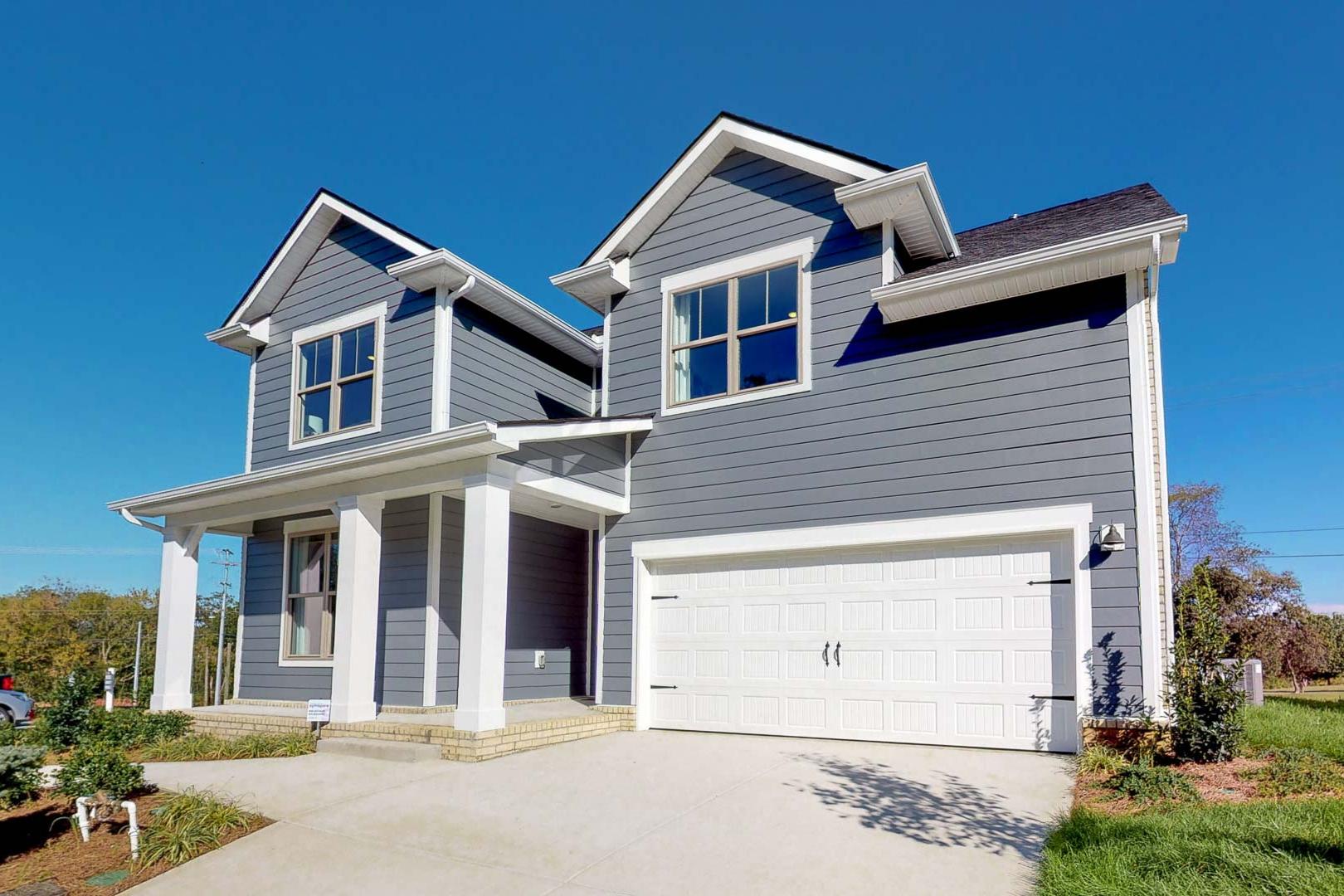 Two-story gray clapboard home exterior at Liberty Creek in Gallatin Tennessee with covered front porch and attached garage