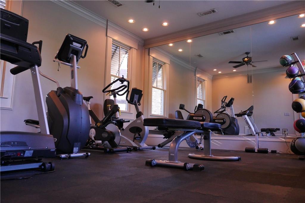 Well-equipped home gym with treadmills, bikes, weights, mirrors in Davidson Homes Seaside B, Woodstock, Georgia