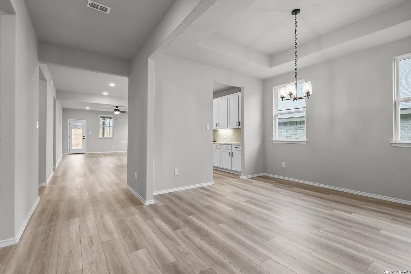 Bright dining area with tray ceiling and wood-look floors in The Glenwood E floor plan, Comanche Ridge, San Antonio.