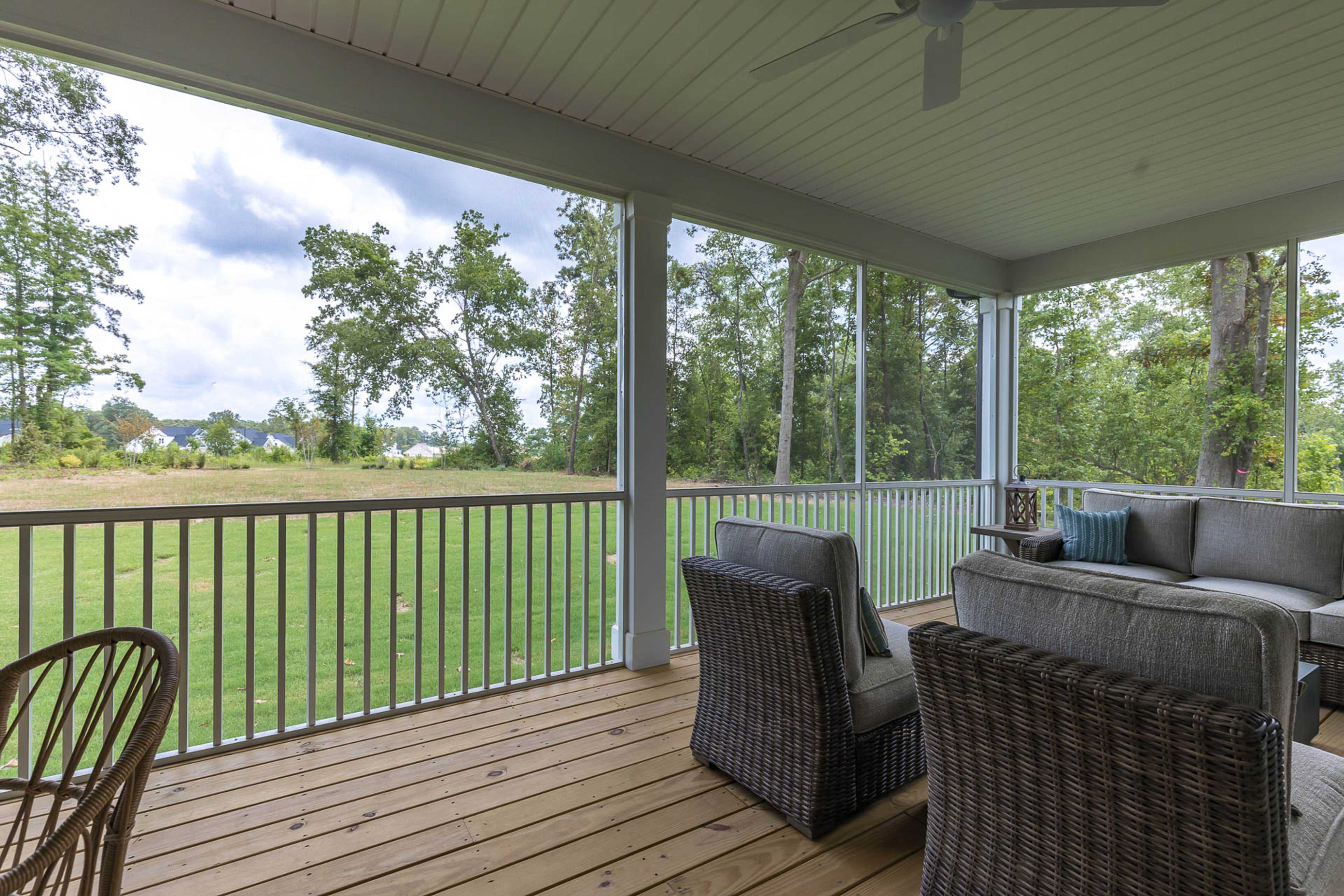 Spacious screened porch with wicker furniture and ceiling fan at Weatherford East in Angier, NC by Davidson Homes