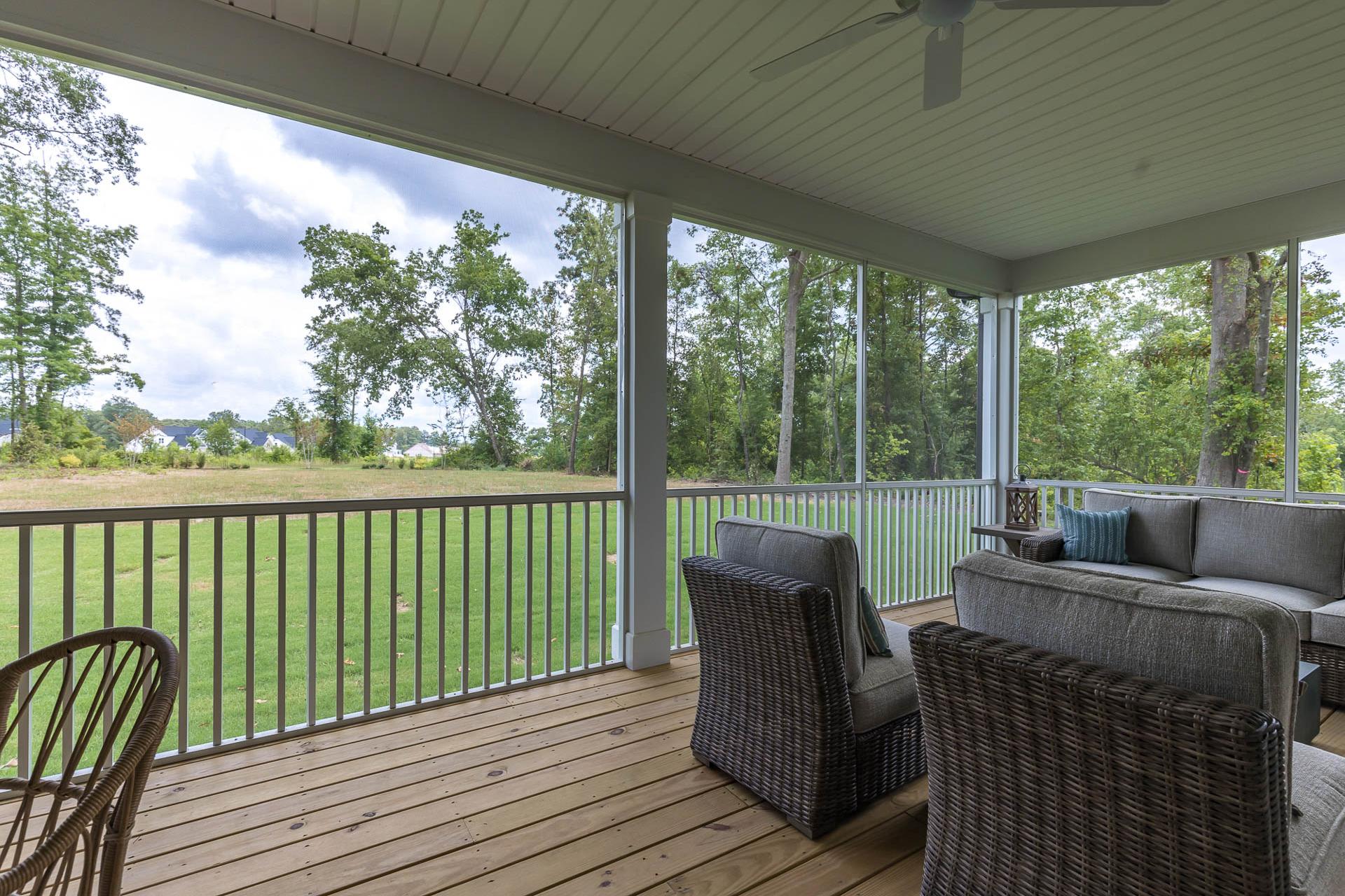 Spacious screened porch with wicker furniture and ceiling fan at Weatherford East in Angier, NC by Davidson Homes