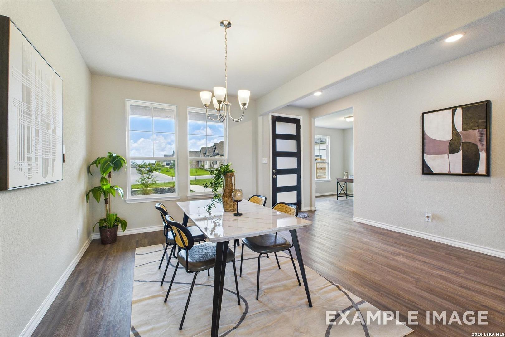 Bright dining area with modern table and chandelier in The Foster F floor plan at Potranco Oaks, Castroville, Texas.