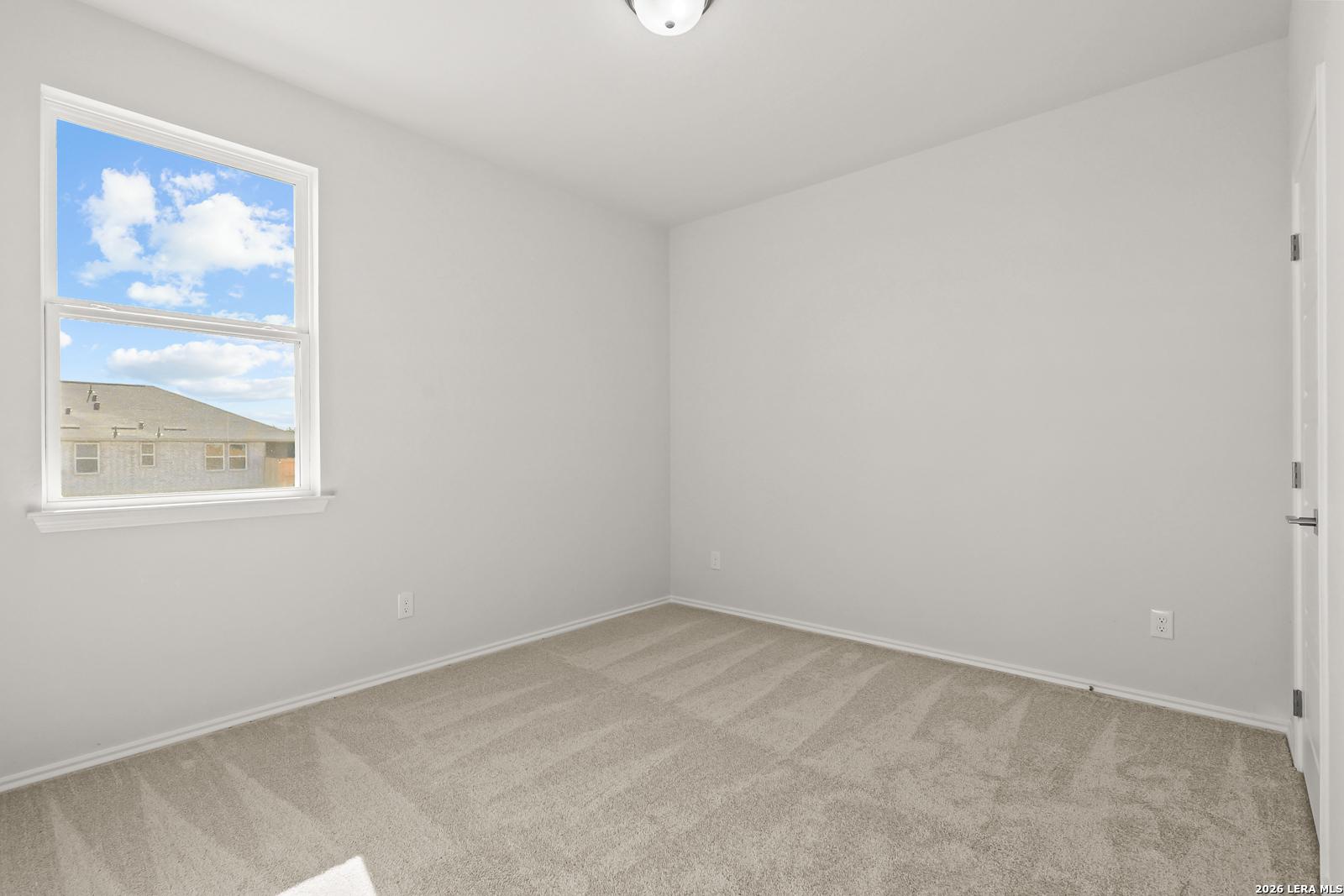 Bright empty bedroom with carpet flooring and large window in Davidson Homes The Daphne I floor plan, Bricewood, San Antonio, Texas