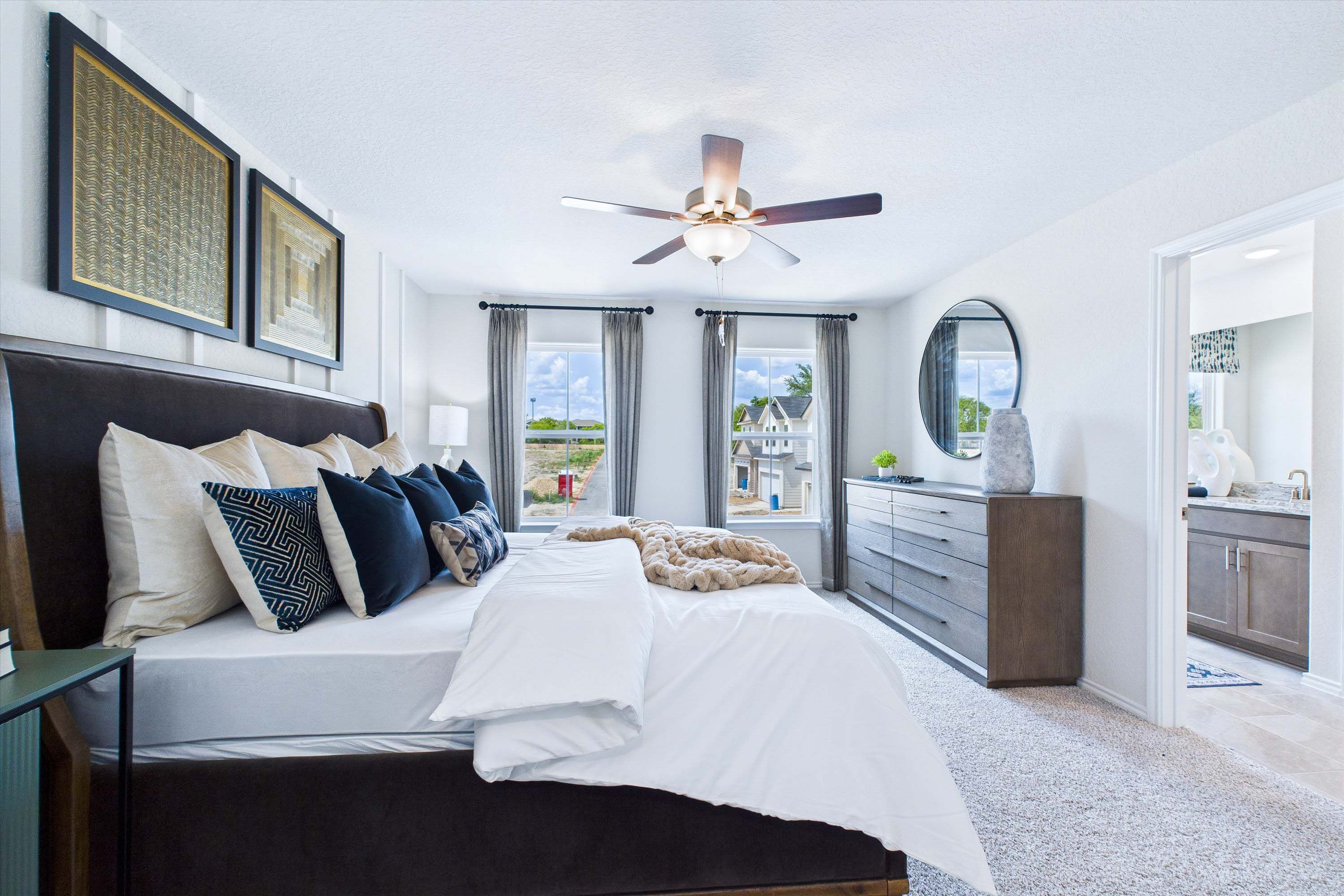 Spacious master suite in The Gillian C featuring a modern bedroom design with plush bedding and an attached bathroom.