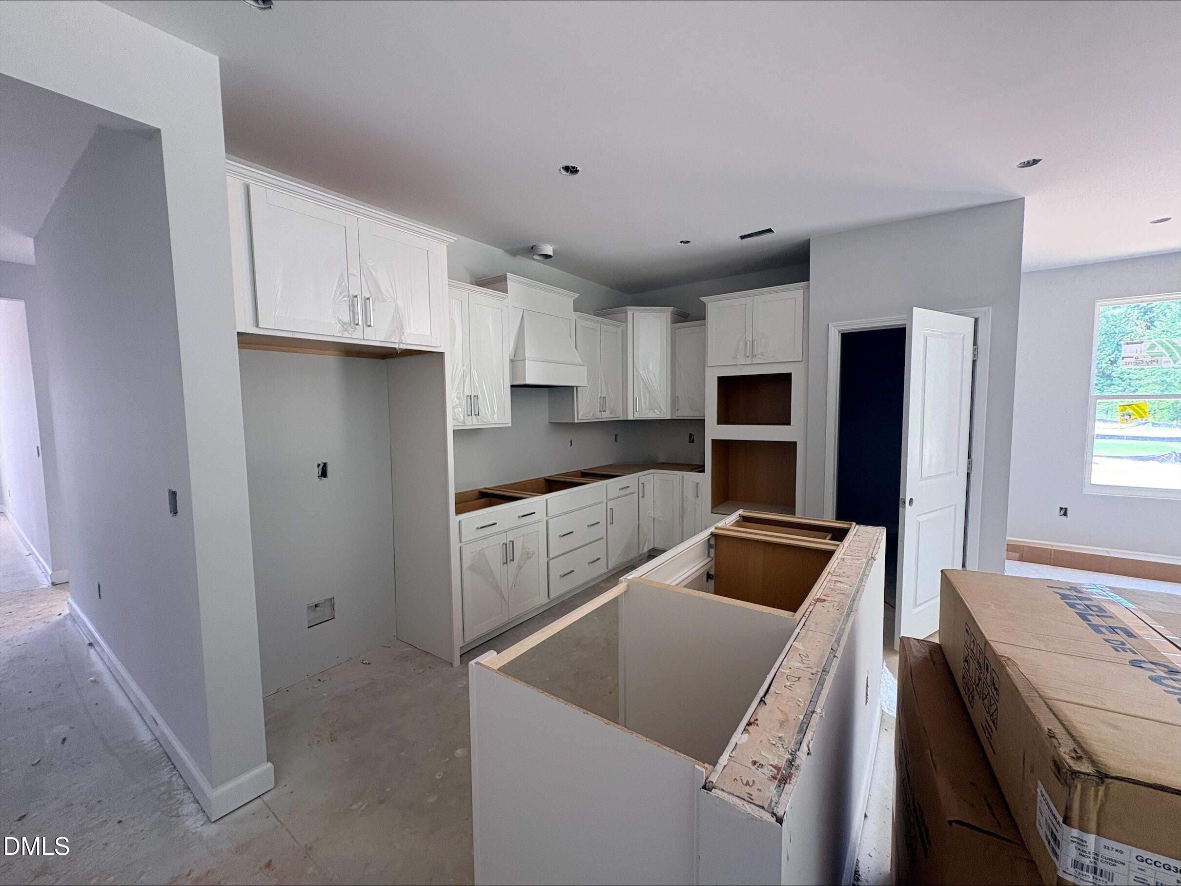 New construction kitchen with white cabinetry and center island in The Daphne D plan, Woodland Crossing, Zebulon, NC.