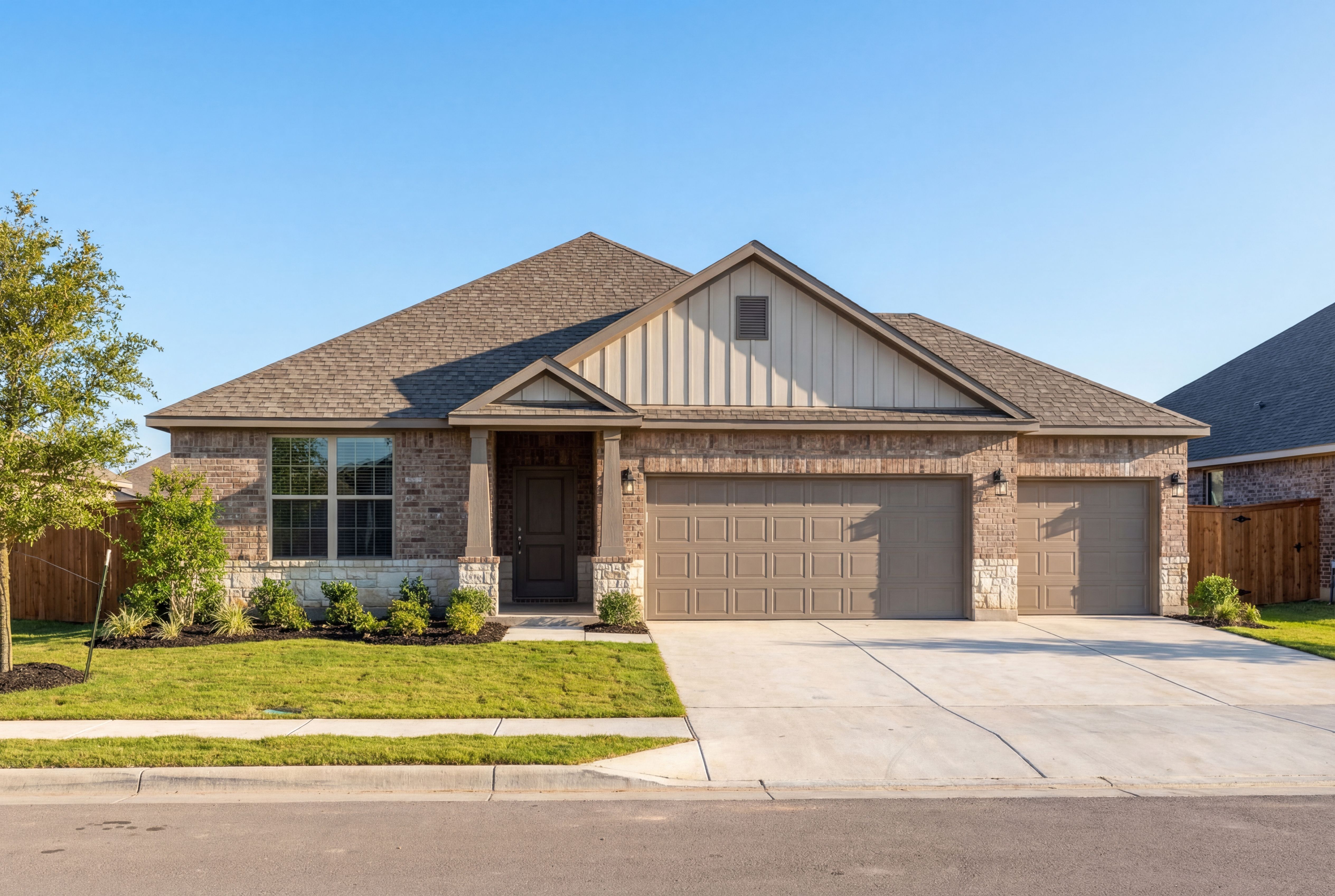 Single-story The Daphne G elevation with 3-car garage, beige siding, stone accents, and front porch in Dayton Texas