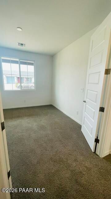 Bright, carpeted bedroom with large window in The Summit A floor plan by Davidson Homes in Westwood, Prescott, Arizona.