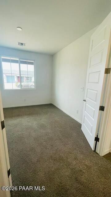 Bright, carpeted bedroom with large window in The Summit A floor plan by Davidson Homes in Westwood, Prescott, Arizona.