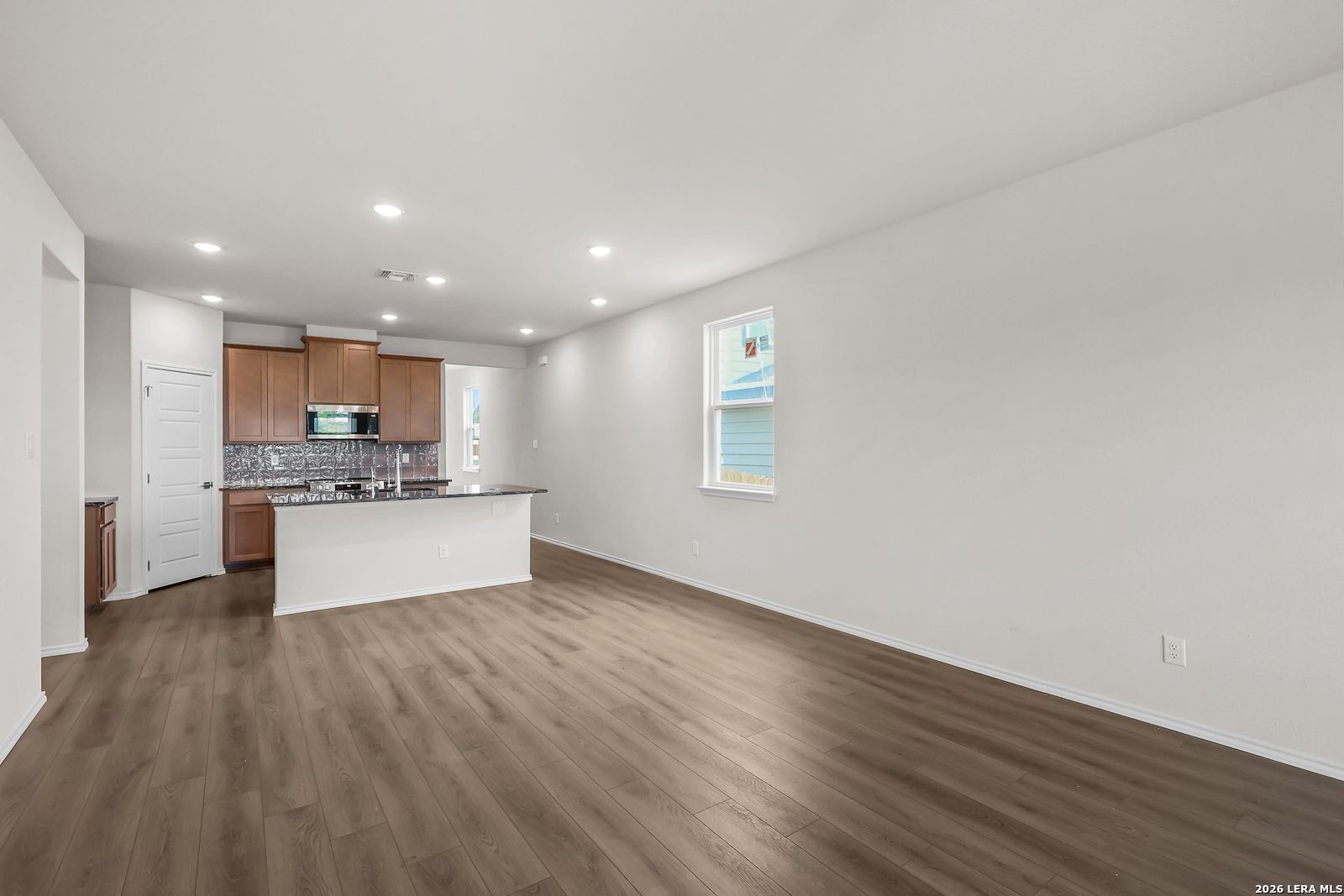 Open-concept kitchen with wood cabinets and island in The San Marcos F floor plan by Davidson Homes, San Antonio, Texas.