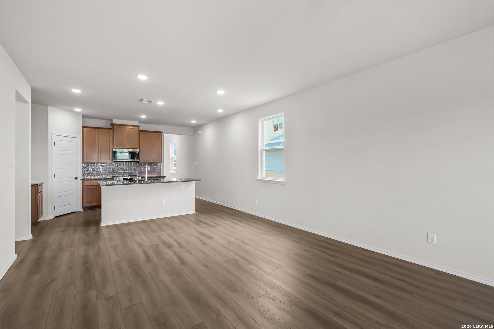 Open-concept kitchen with wood cabinets and island in The San Marcos F floor plan by Davidson Homes, San Antonio, Texas.