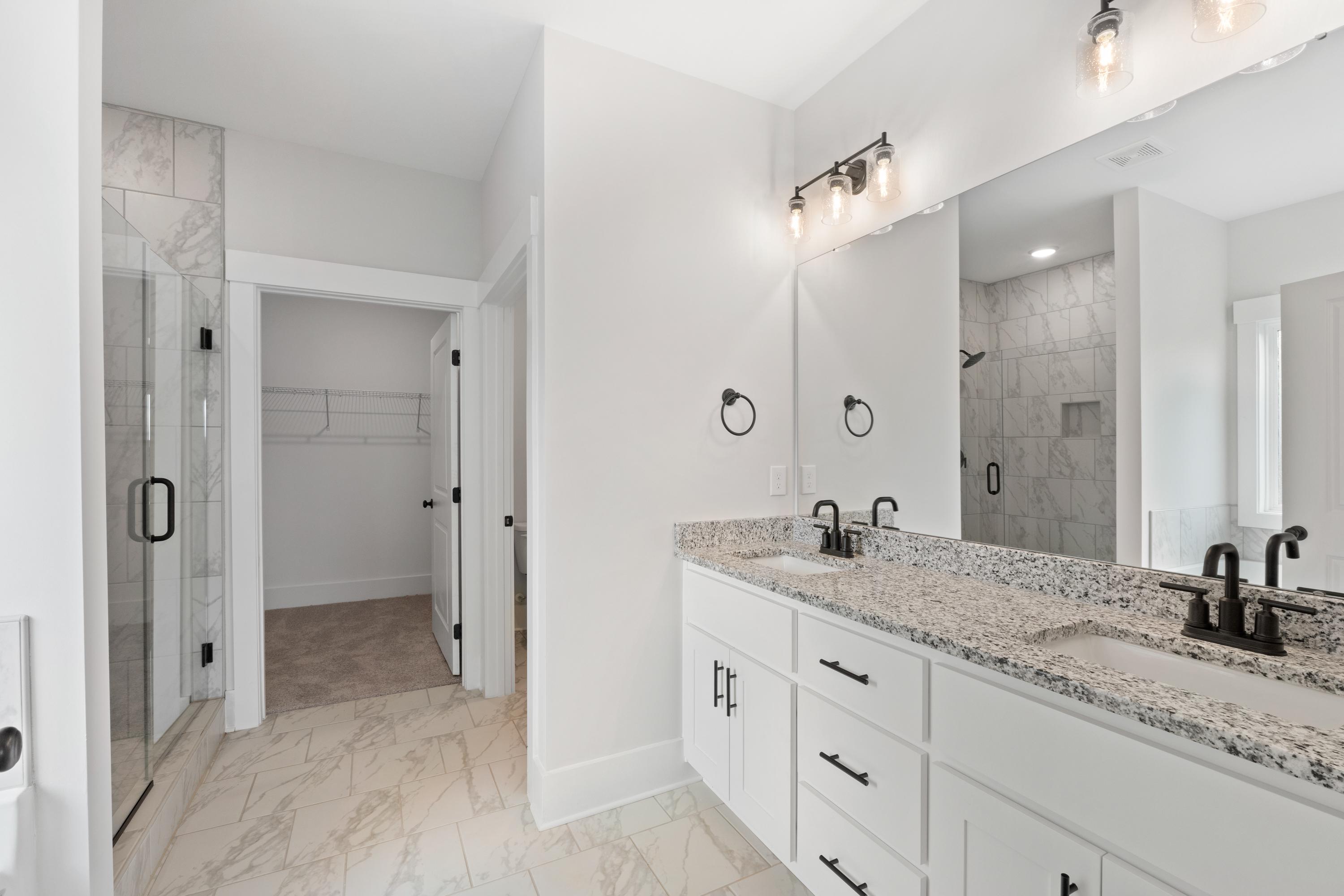 Spacious master bathroom at The Villas at Barnett's Crossing in Madison Alabama with double vanity quartz countertop walk-in shower and closet