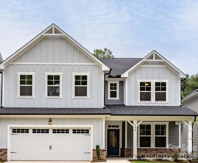 Two-story gray craftsman-style home with 2-car garage and covered front porch at Enclave at Belmont, Belmont, North Carolina