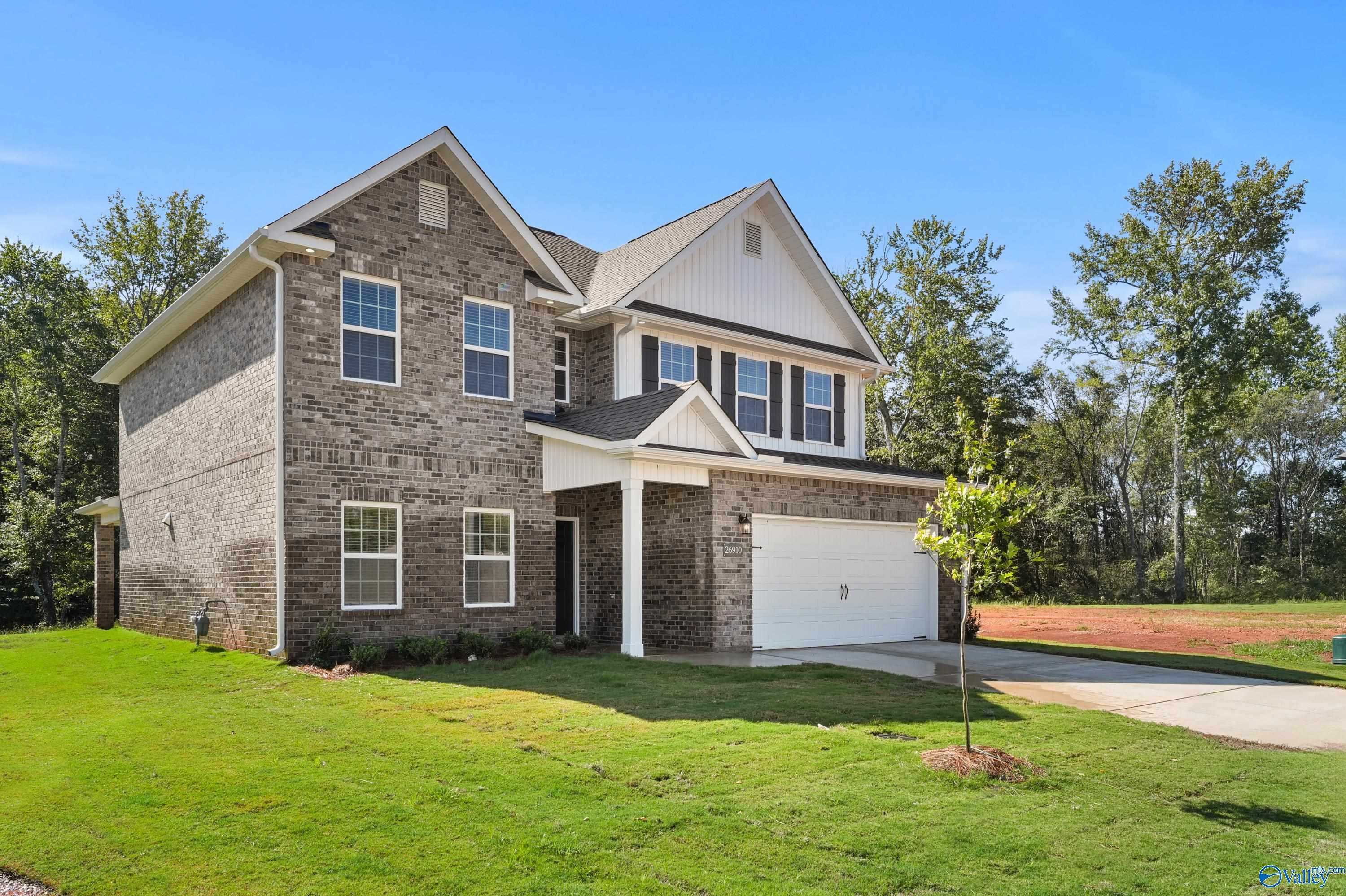 Two-story brick home with 2-car garage, front porch, lush green lawn in Ricketts Farm, Athens, Alabama - Davidson Homes Shelby A