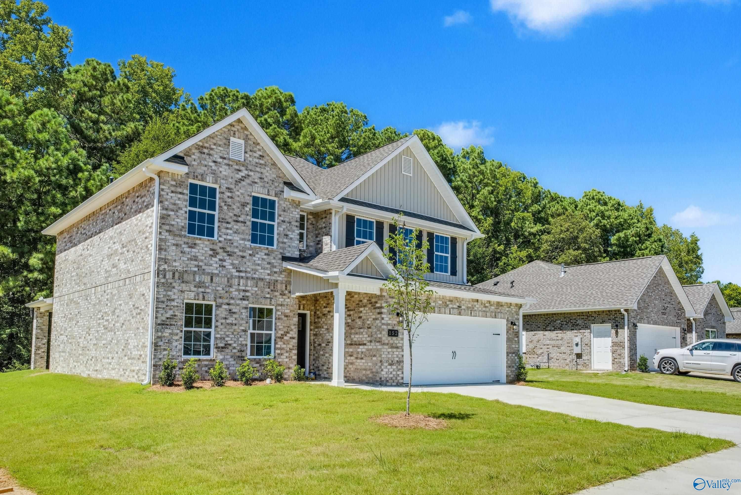 Two-story brick home with 2-car garage, driveway, and lush green yard in The Highlands, Arab, Alabama - Davidson Homes Shelby A