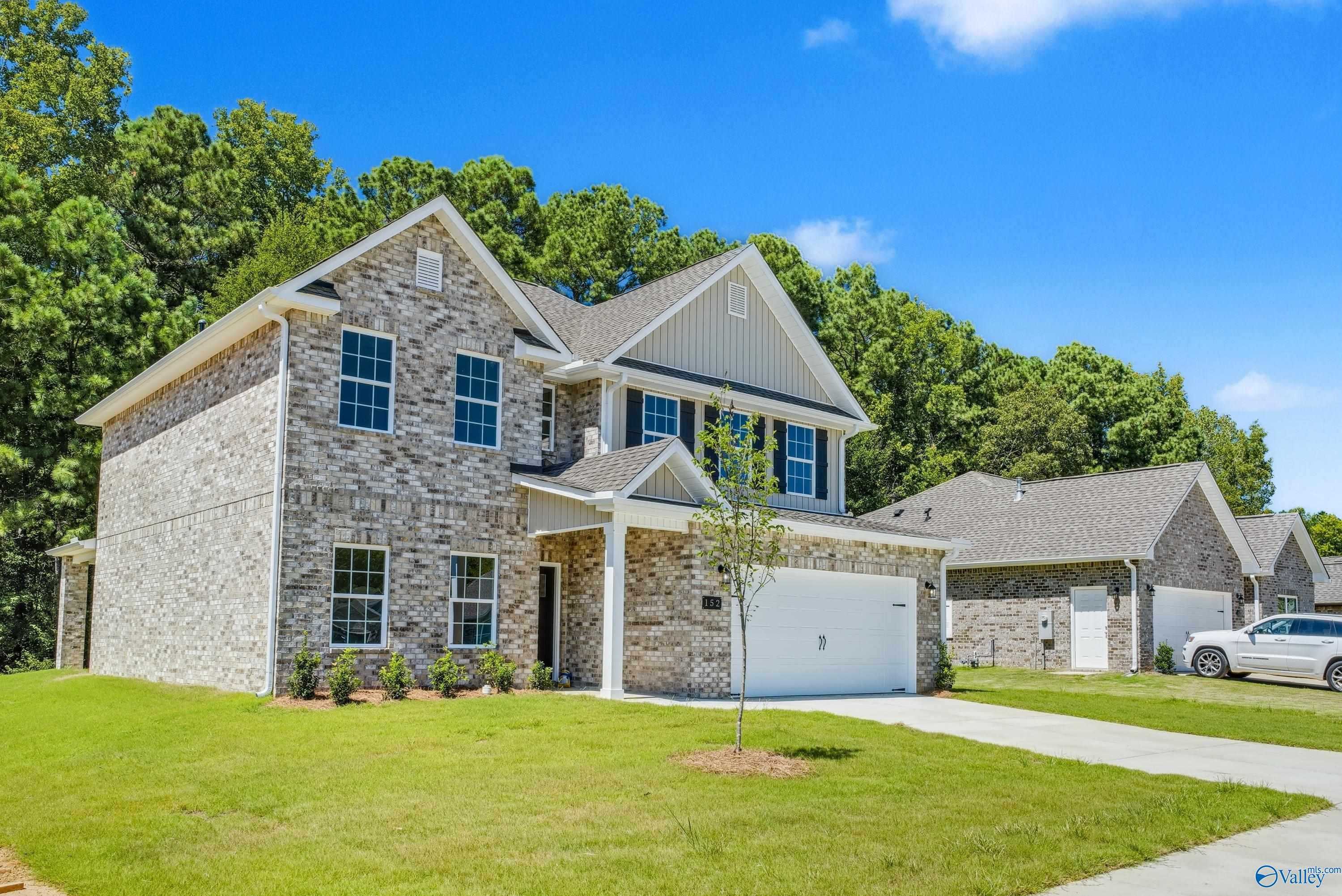 Two-story brick home with 2-car garage, driveway, and lush green yard in The Highlands, Arab, Alabama - Davidson Homes Shelby A