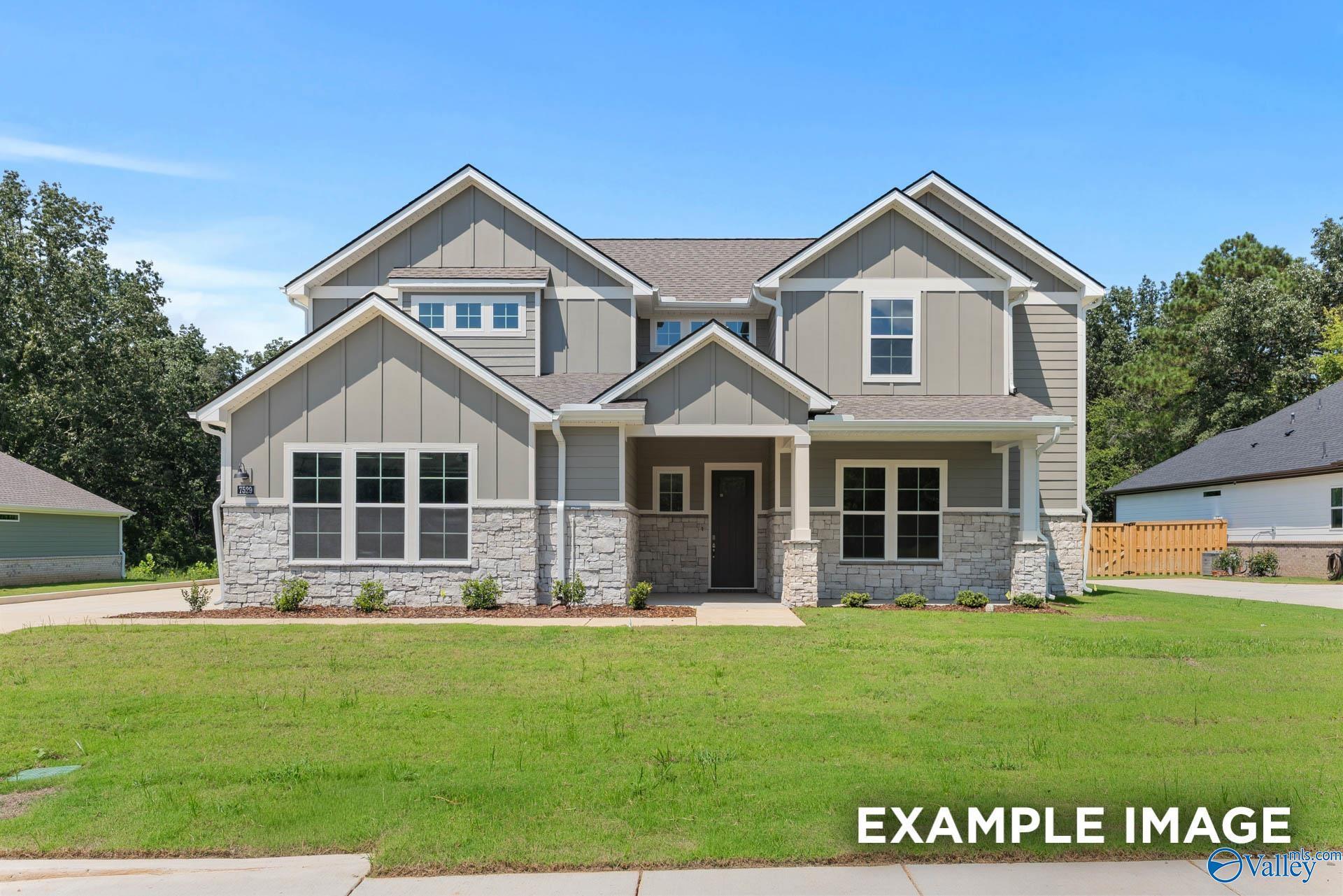 Modern two-story gray Craftsman home with stone accents, front porch, and manicured lawn in The Meadows at Hampton Cove, Owens Cross Roads, Alabama