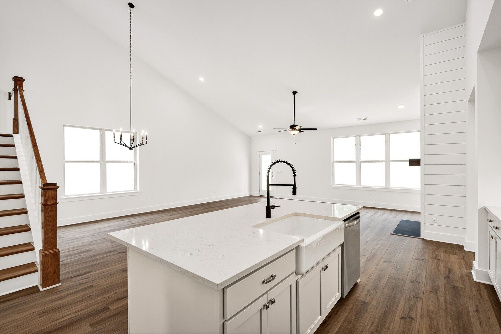 Spacious open-concept kitchen with white quartz island, hardwood floors, and staircase in The Ridgeport C, Gallatin, TN