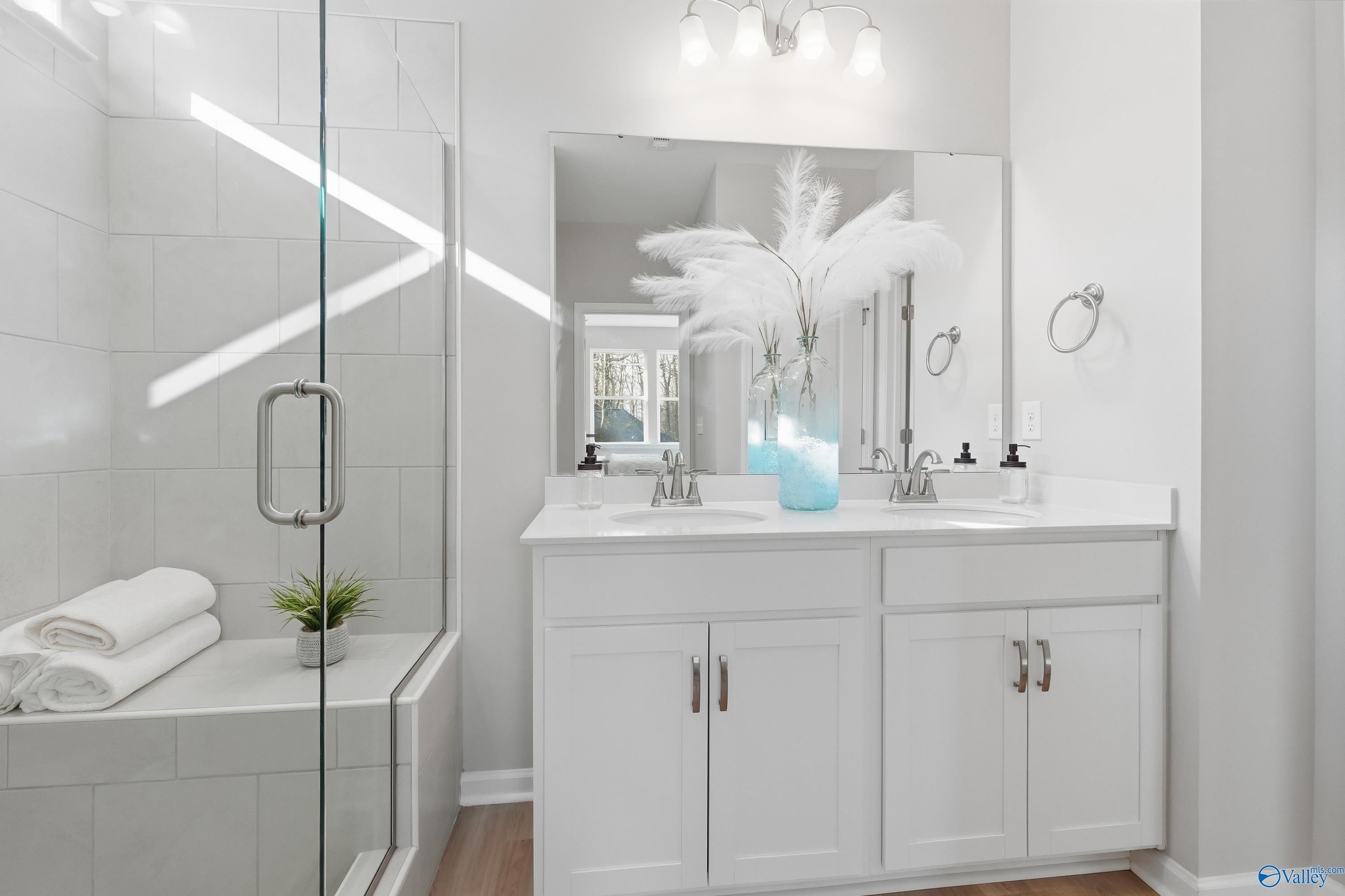 Modern master bath with frameless glass shower, double vanity, white cabinets in Davidson Homes The Polaris, Fayetteville, TN