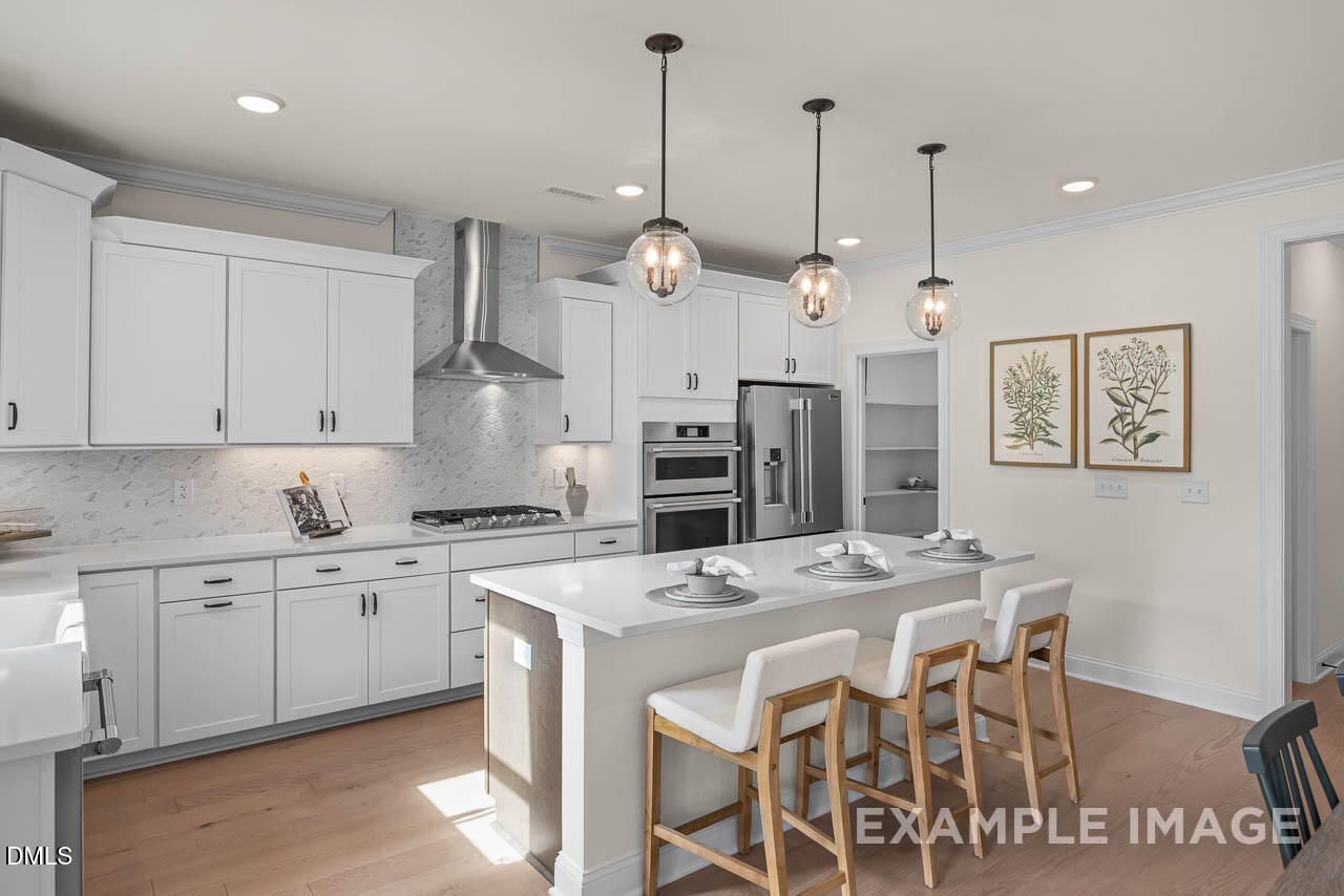 Bright modern kitchen with white shaker cabinets, quartz island, stainless appliances in Davidson Homes Crawford D, Angier NC