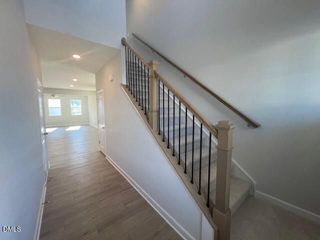 Elegant two-story staircase with wrought iron balusters and oak handrail in 4-bedroom Adalynn B home, Lillington, NC