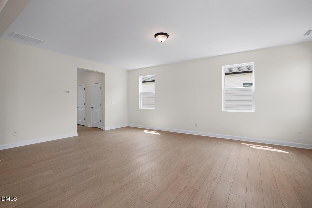 Spacious, light-filled living area with hardwood floors in The Gavin C floor plan at Gregory Village, Lillington, NC.