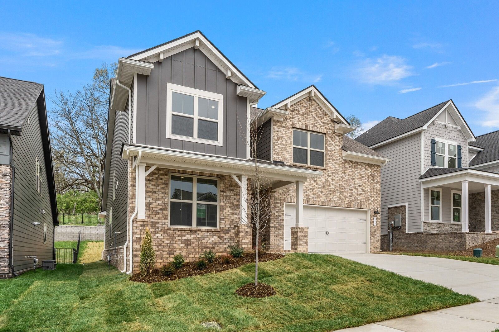 Modern two-story brick and siding Ridgeport C home by Davidson Homes in Woods Crossing, Gallatin, TN, with two-car garage and landscaped yard