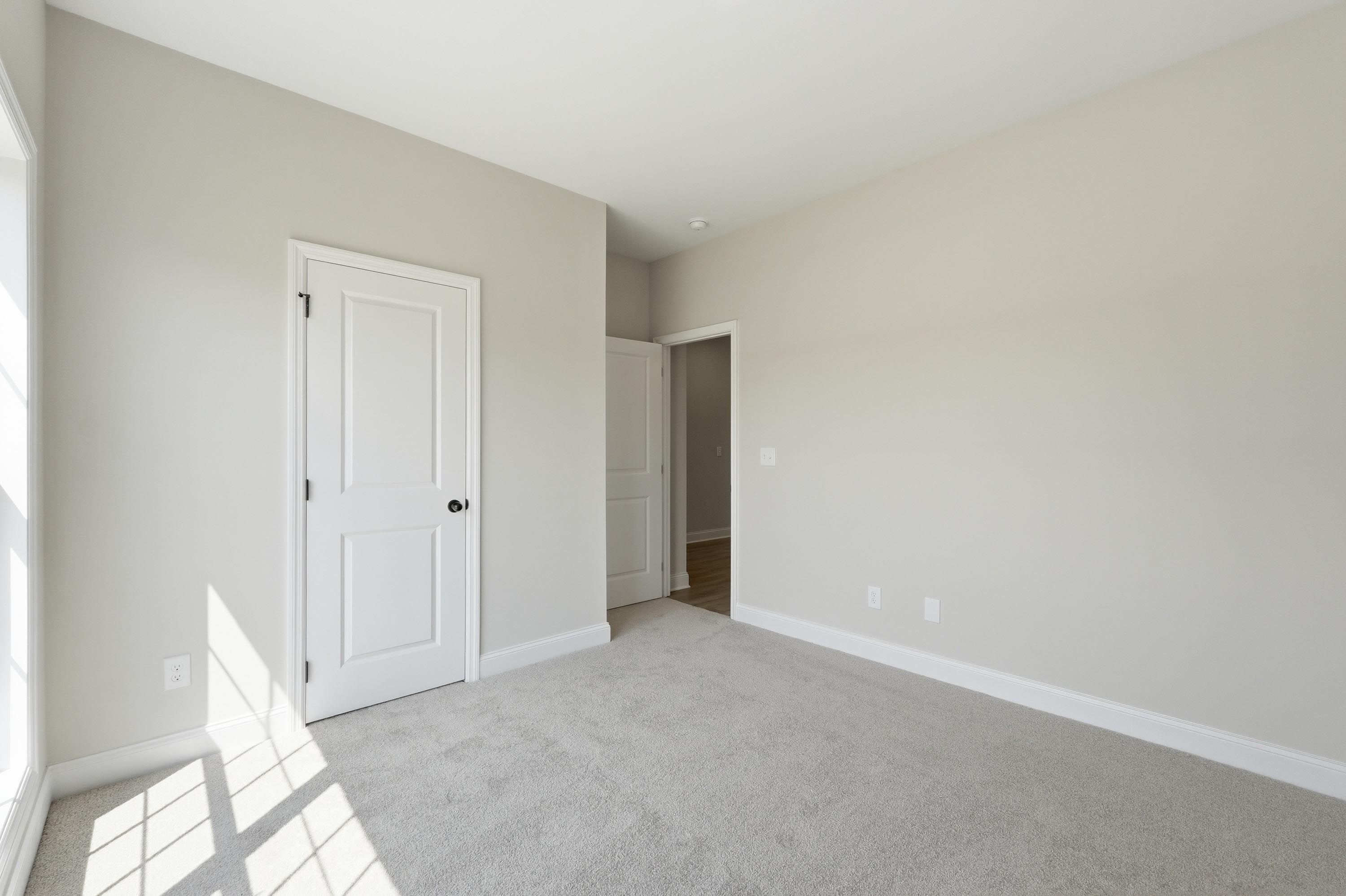 Spacious neutral bedroom in The Glen B floor plan by Davidson Homes featuring plush carpeting and white interior doors.