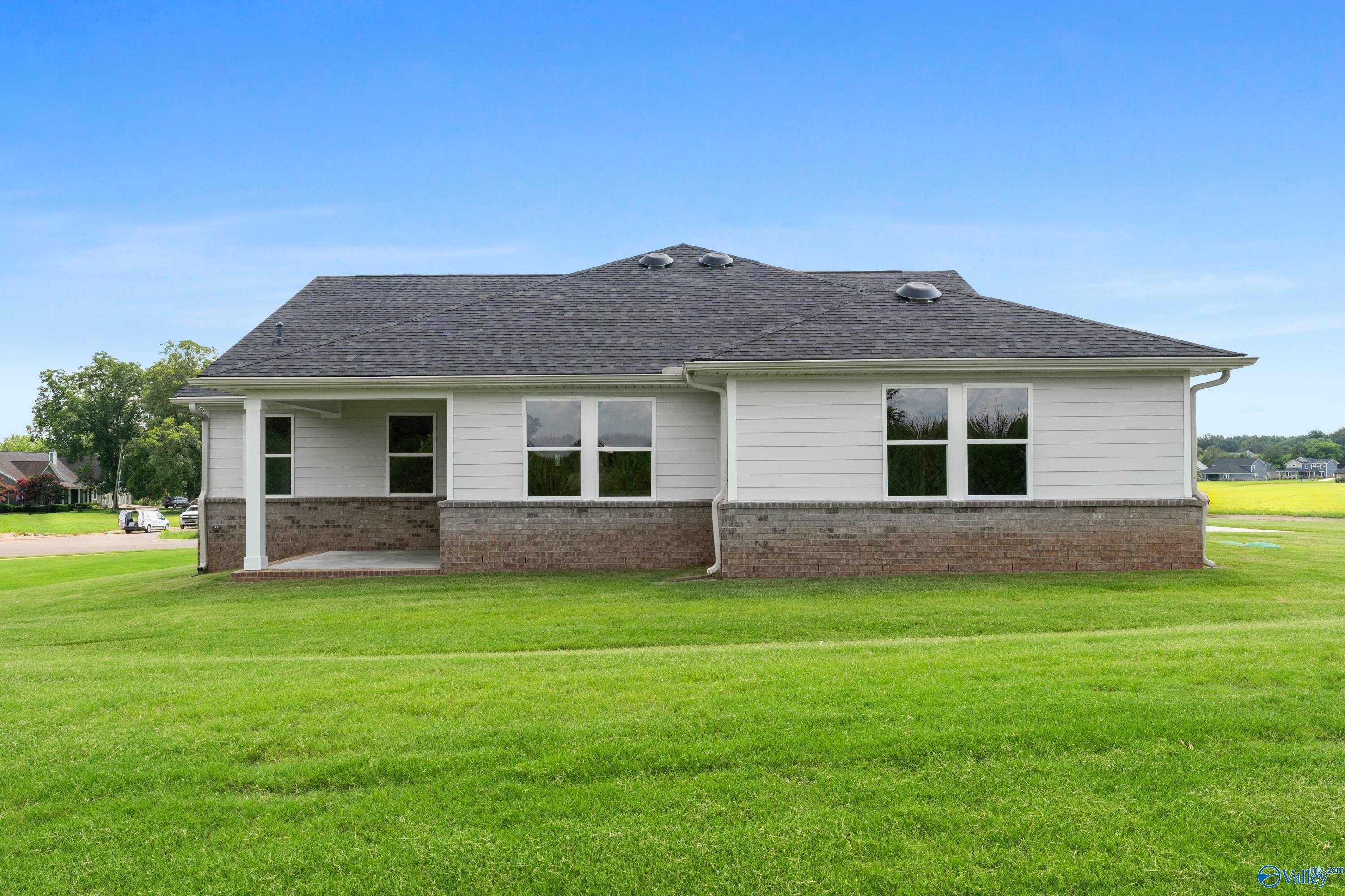 Single-story Arcadia home exterior with brick base, covered porch, and large windows in Riverton Preserve, Huntsville, Alabama