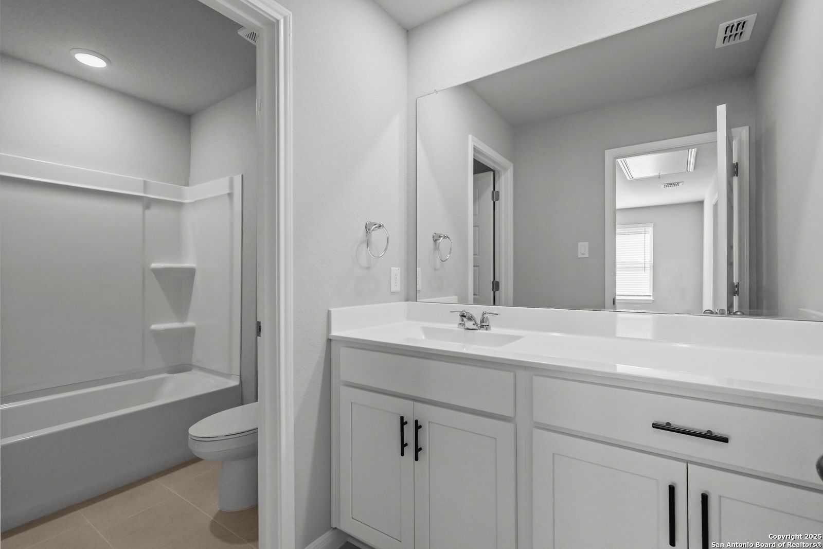 Modern master bath with dual sinks, freestanding tub, glass shower, and walk-in closet access in Davidson Homes Gillian C, San Antonio, TX