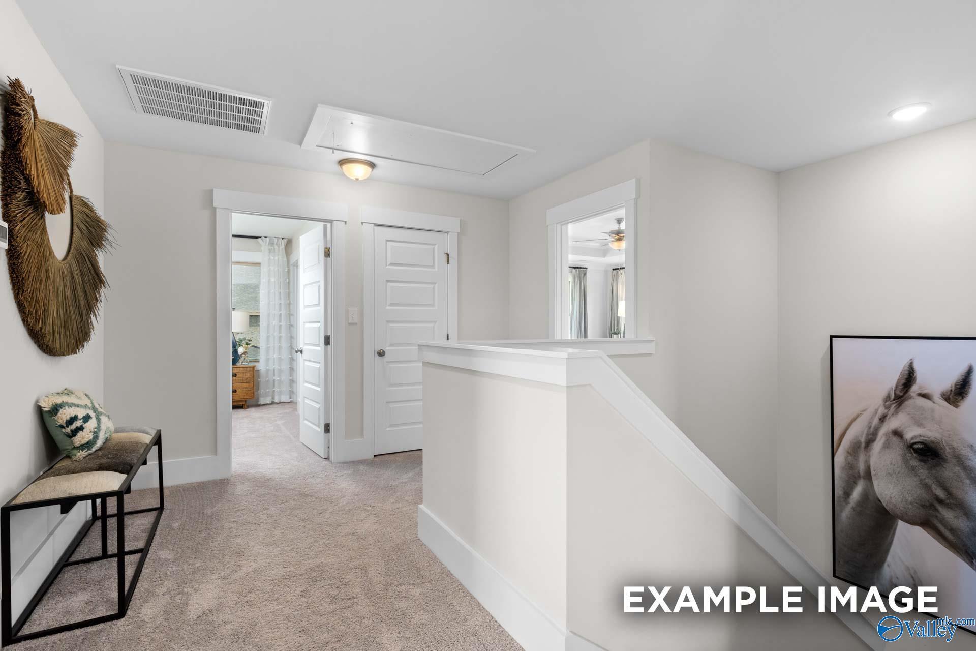 Bright carpeted upstairs loft hallway with white doors and staircase railing in Davidson Homes Chelsea A plan, Toney, Alabama