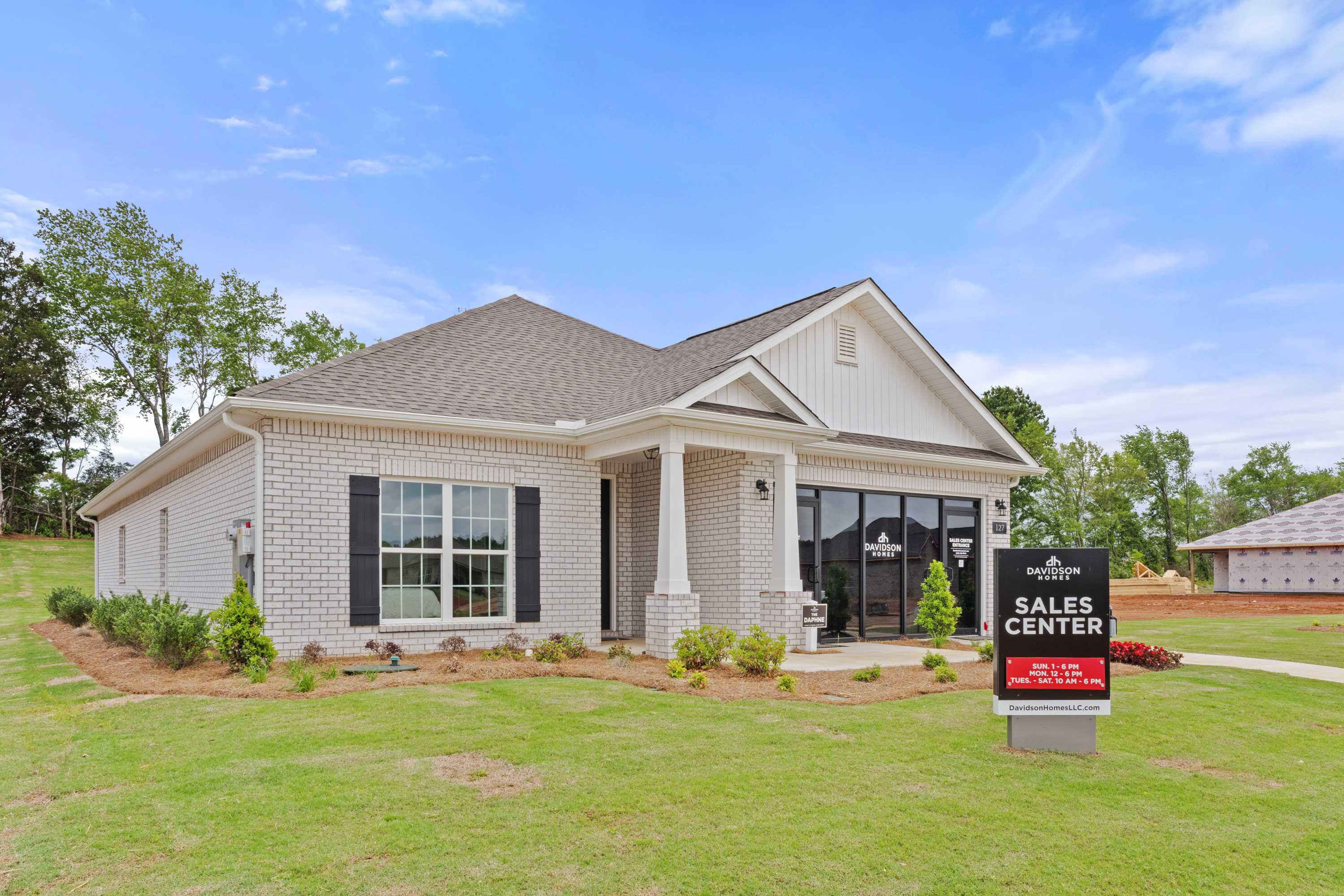 Davidson Homes sales center: brick ranch-style home exterior at Ivy Hills in Toney, Alabama with covered porch and shrubs