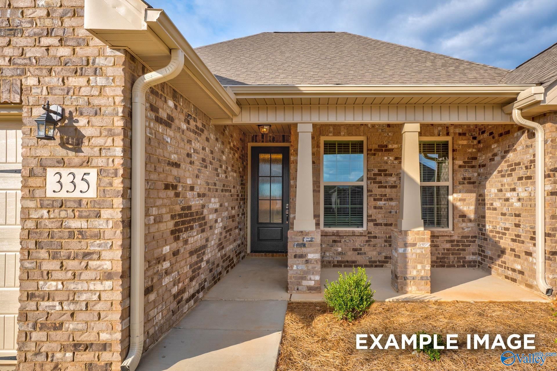 Brick-front single-story home with 2-car garage, covered porch, and address 335 in Pikes Ridge, Meridianville, Alabama