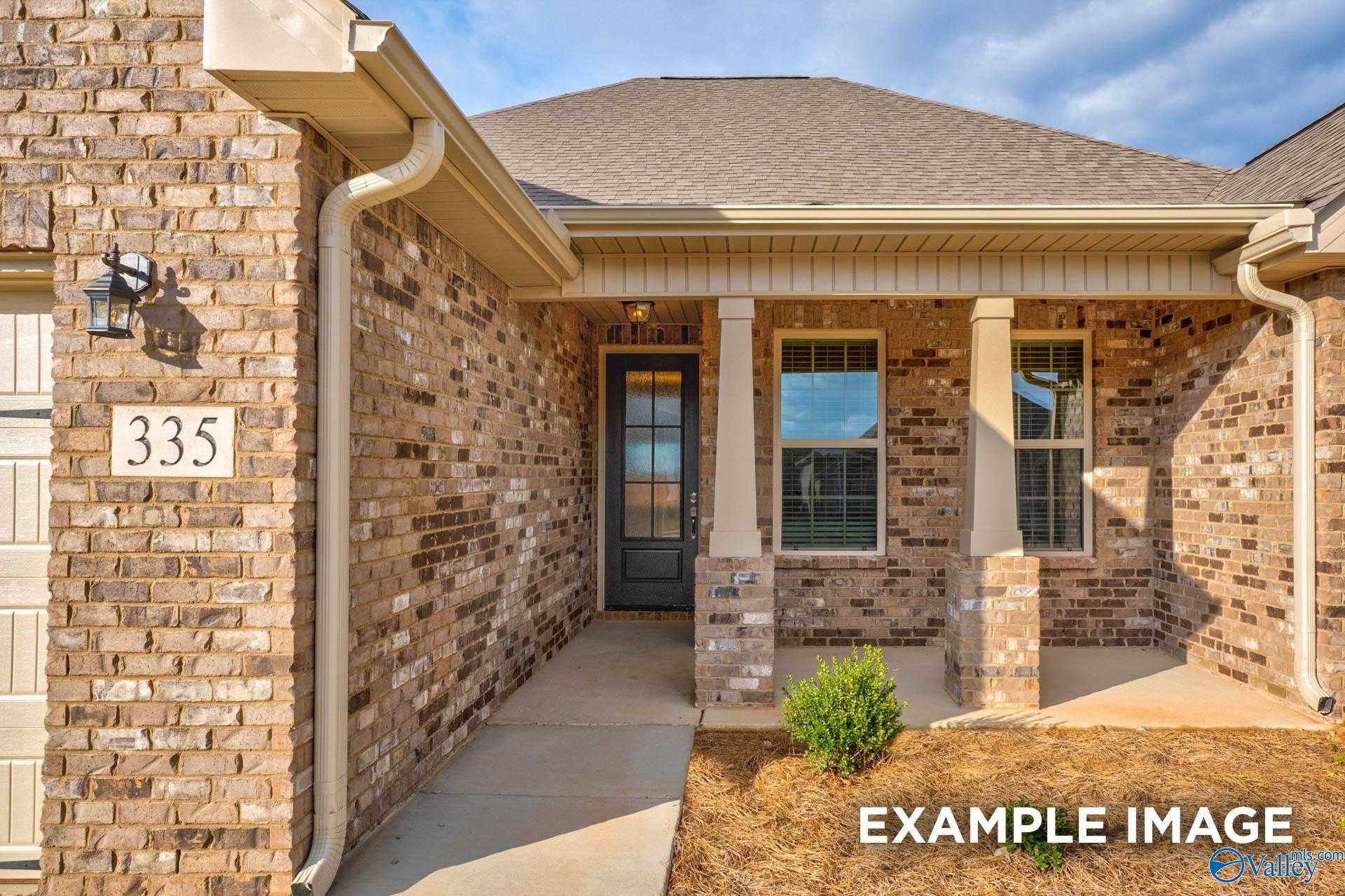 Brick-front single-story home with 2-car garage, covered porch, and address 335 in Pikes Ridge, Meridianville, Alabama