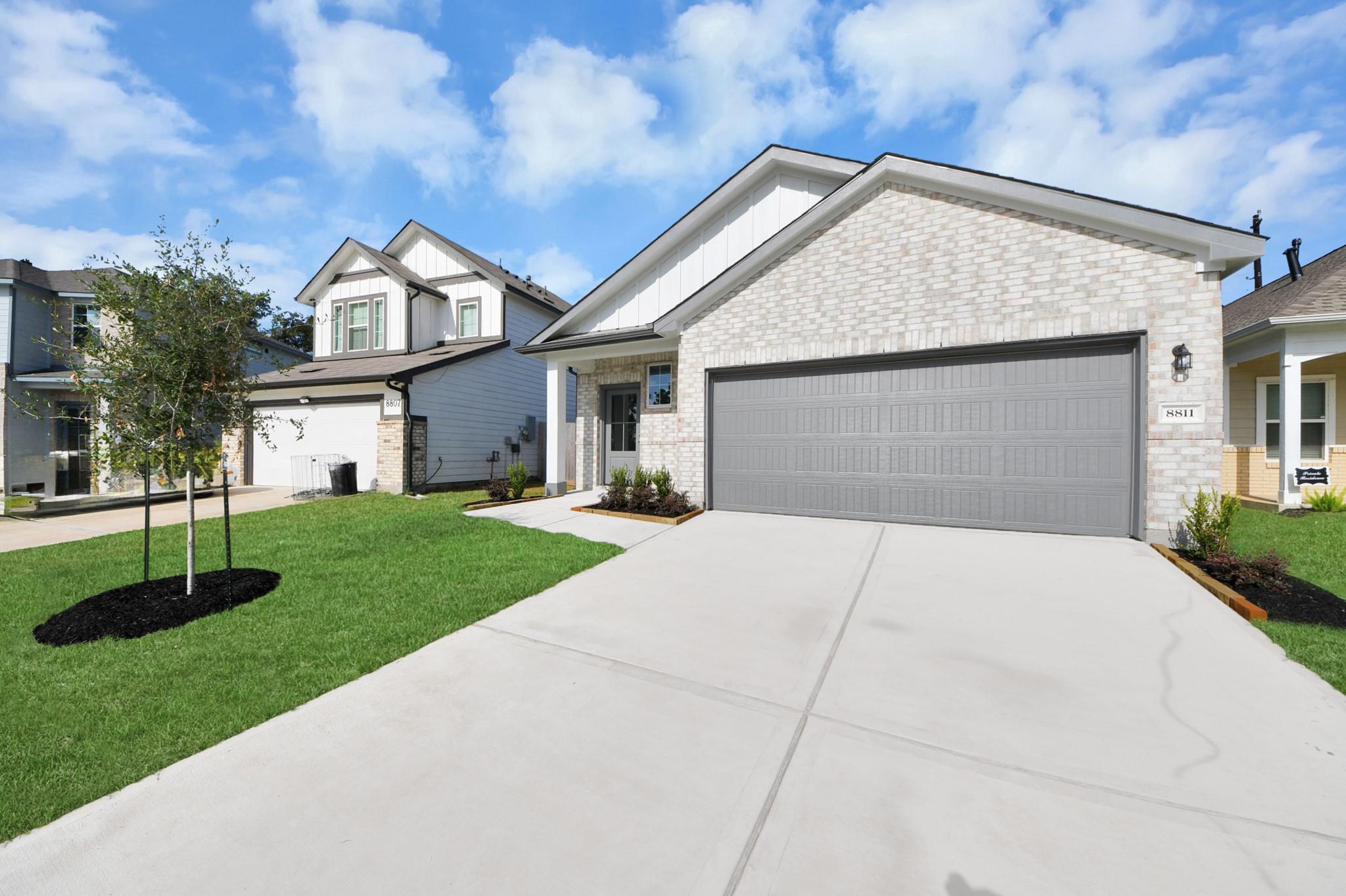 Brick exterior of The Frio F single-story home with 2-car garage and landscaped yard at Robins Landing, Houston by Davidson Homes