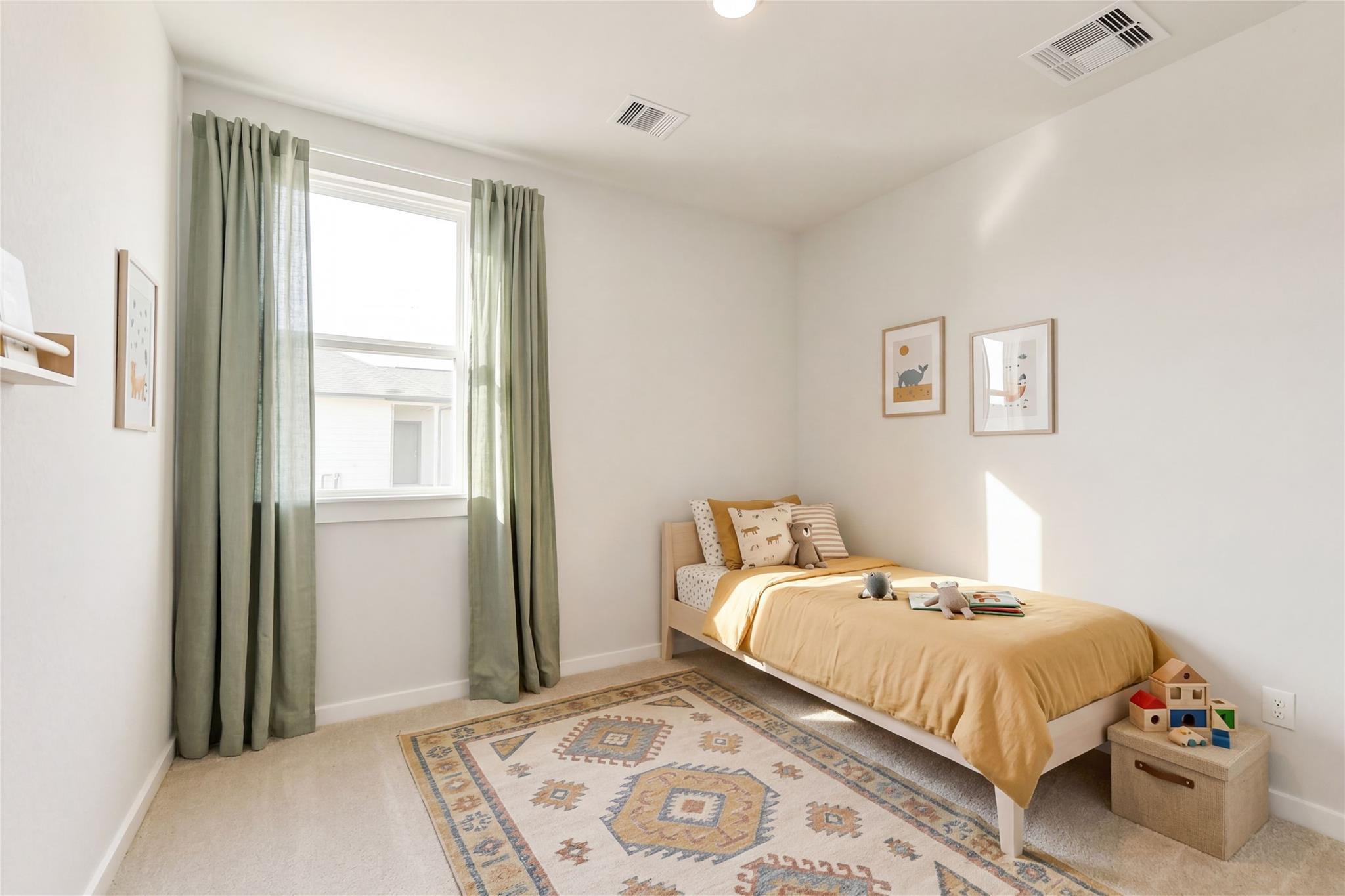 Cozy child's bedroom featuring yellow twin bed, stuffed animals, wooden toys, and geometric rug in Davidson Homes The Frio G, Conroe, Texas
