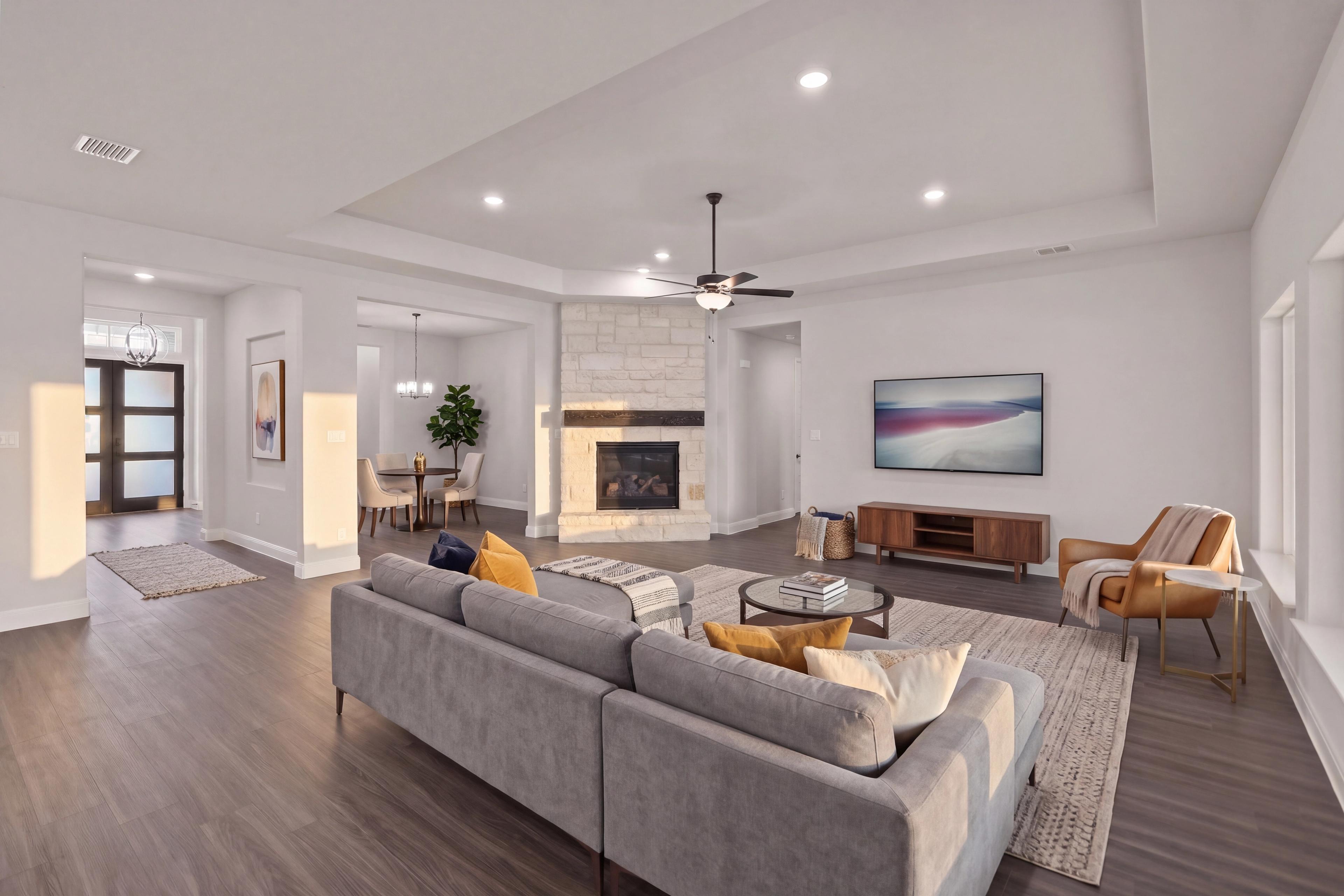 Open concept family room with stone fireplace at Potranco Oaks in Castroville, TX