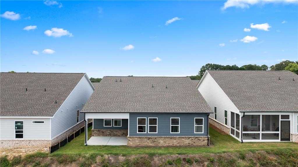 Aerial view of The Edison A 1-story home with blue siding, covered patio, screened porch, and green yard in Kelly Preserve, Loganville, GA