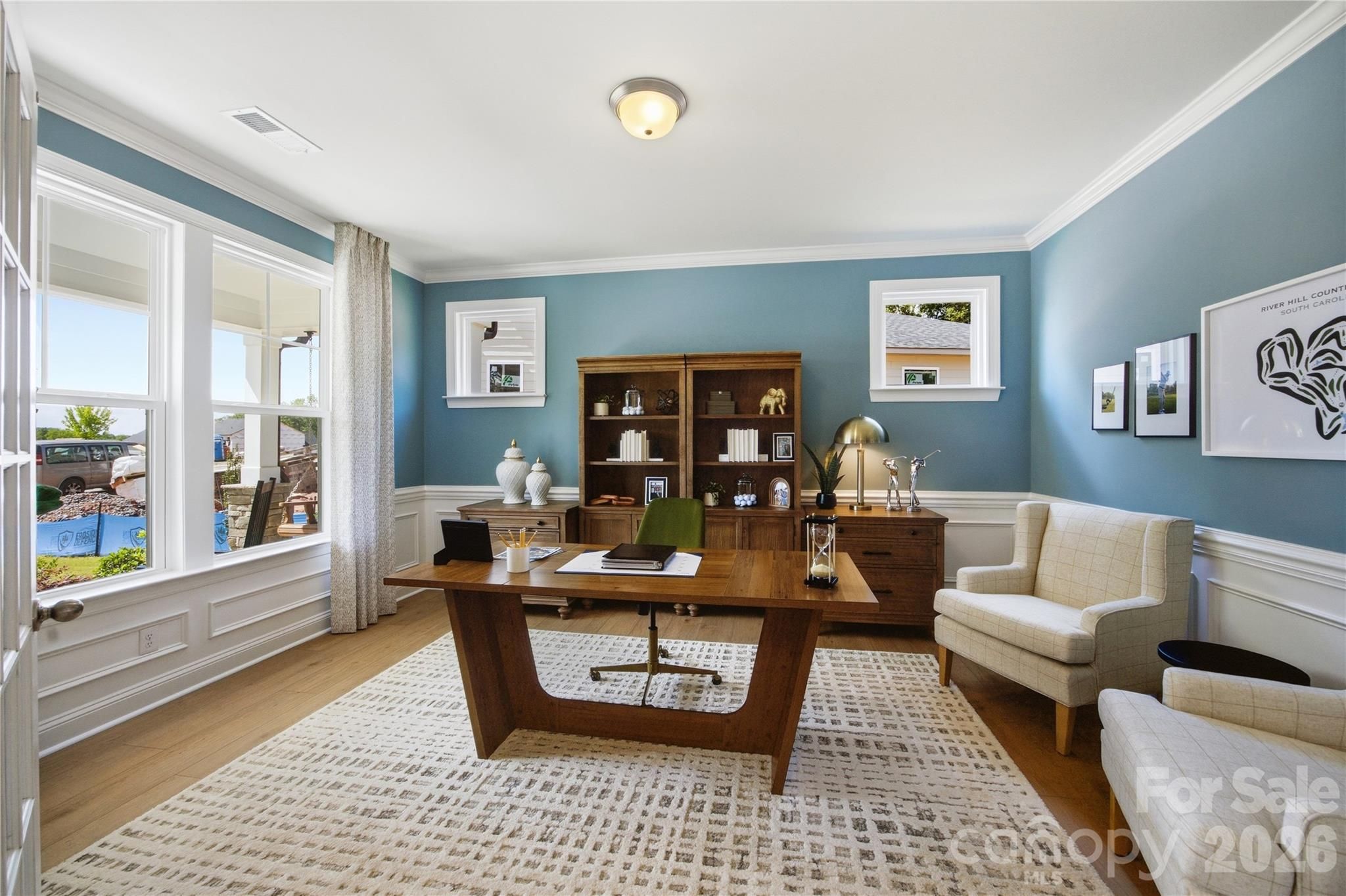 Bright home office with blue walls, wood desk, and built-in shelving in Davidson Homes' The Hickory C II, Enclave at Belmont, NC