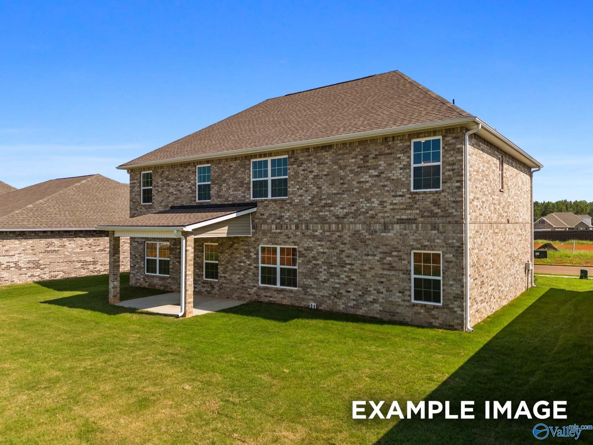 Brick 1.5-story Madison A home with covered porch, multiple windows, and green lawn in Kendall Downs, Toney, Alabama