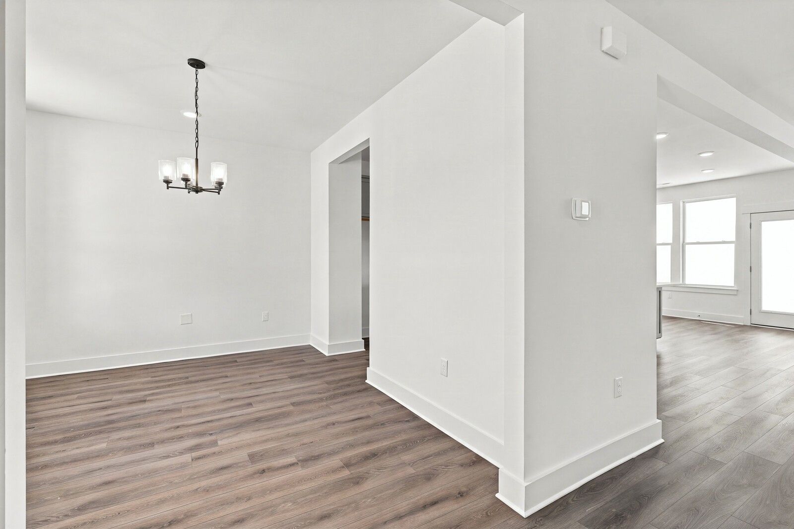 Bright dining area with chandelier and luxury vinyl plank flooring in Davidson Homes Willow B, Gallatin, Tennessee