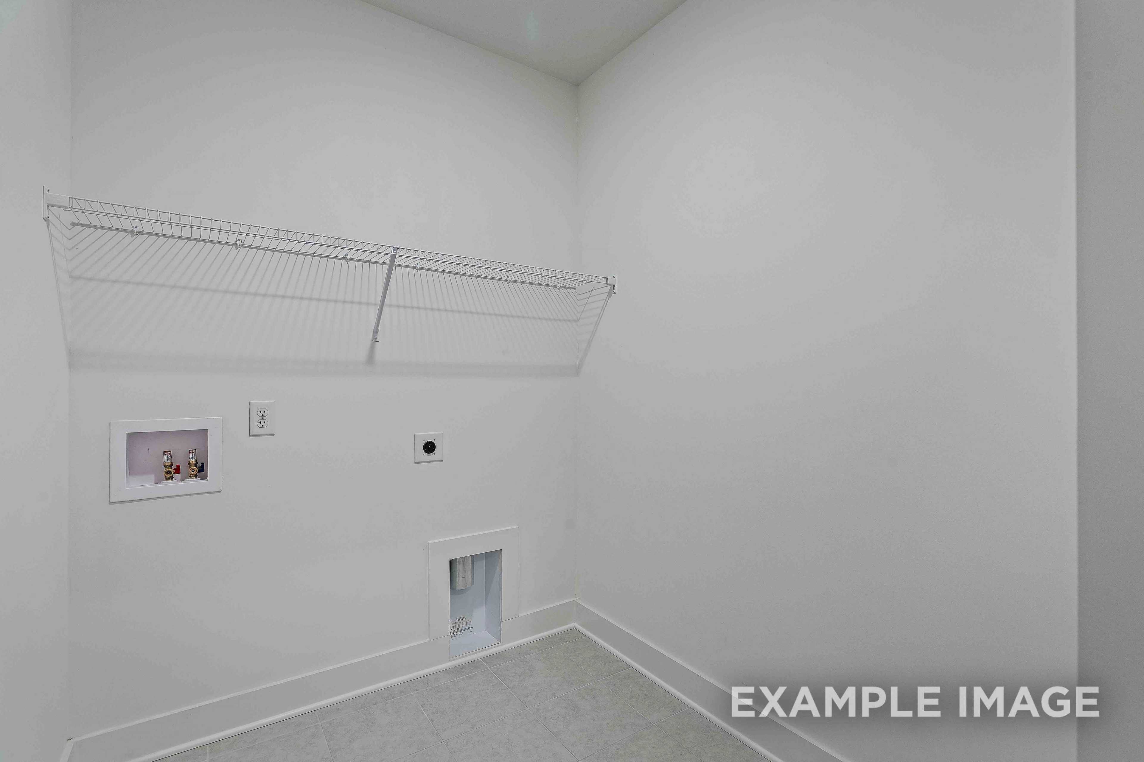 Spacious laundry room in The Charleston home design with wire shelving, washer dryer hookups, and utility sink