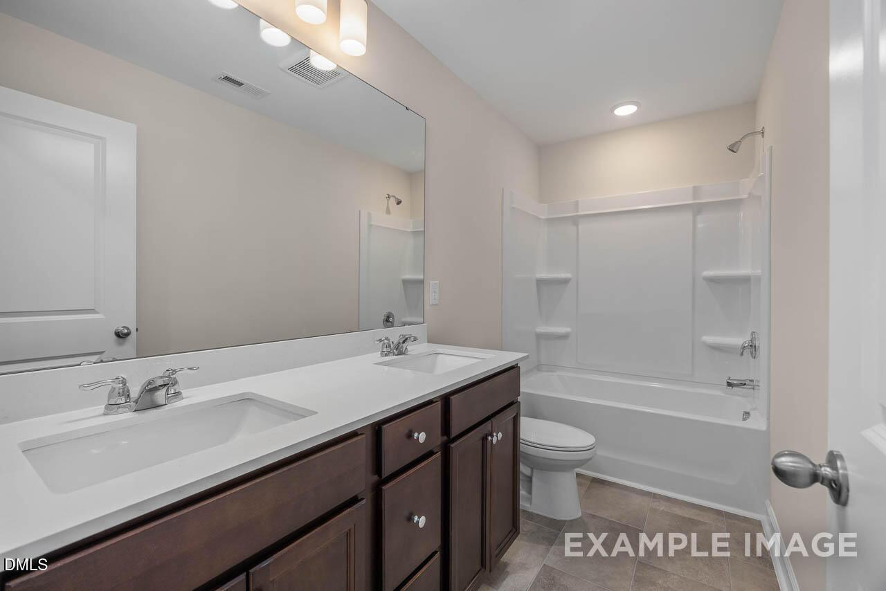 Modern master bathroom with double vanity, soaking tub, and glass shower in Davidson Homes The Graham, Fuquay-Varina, NC