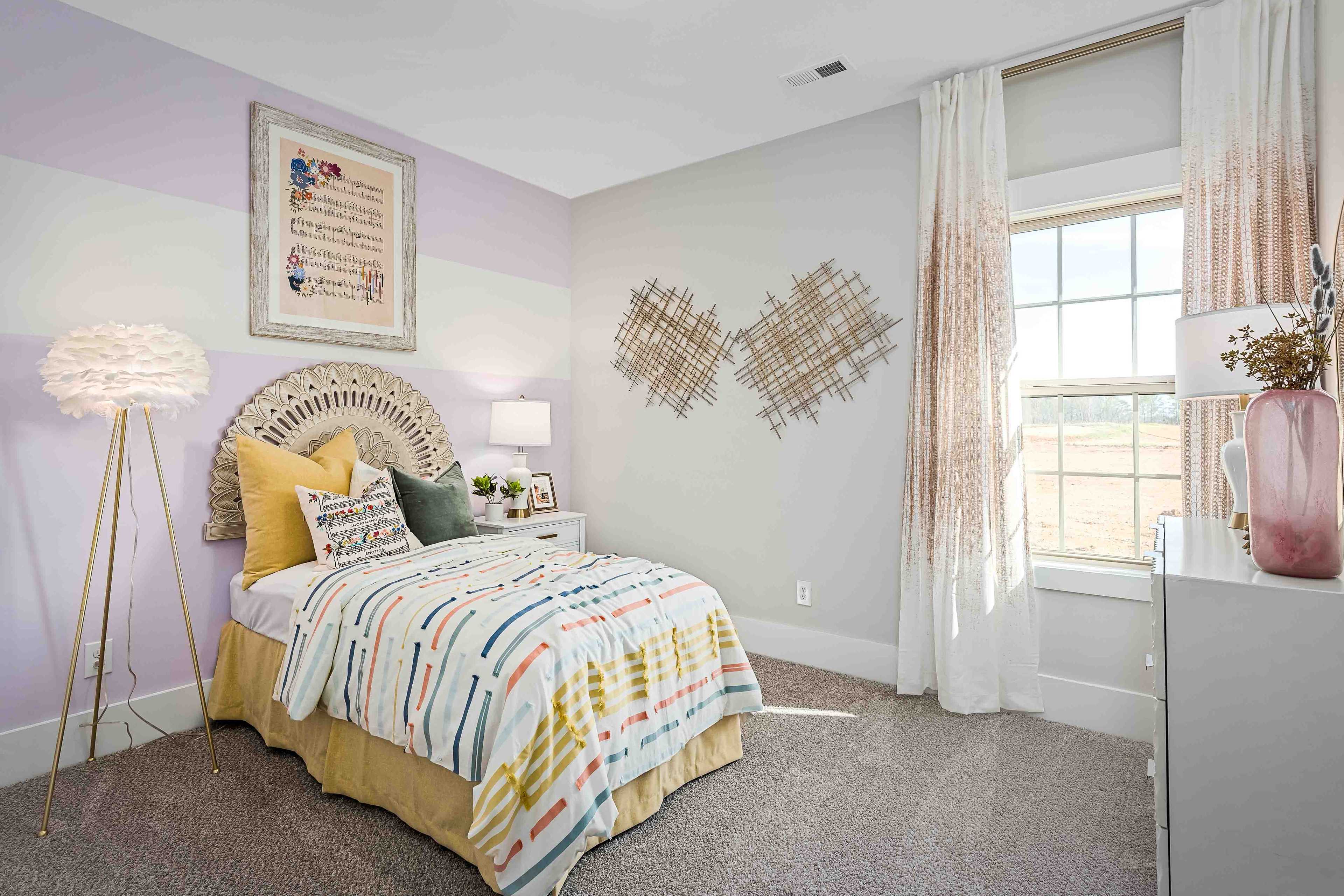 Charming kids bedroom in Cain Park Hartselle AL with purple walls colorful quilted bed woven headboard and sheer curtains